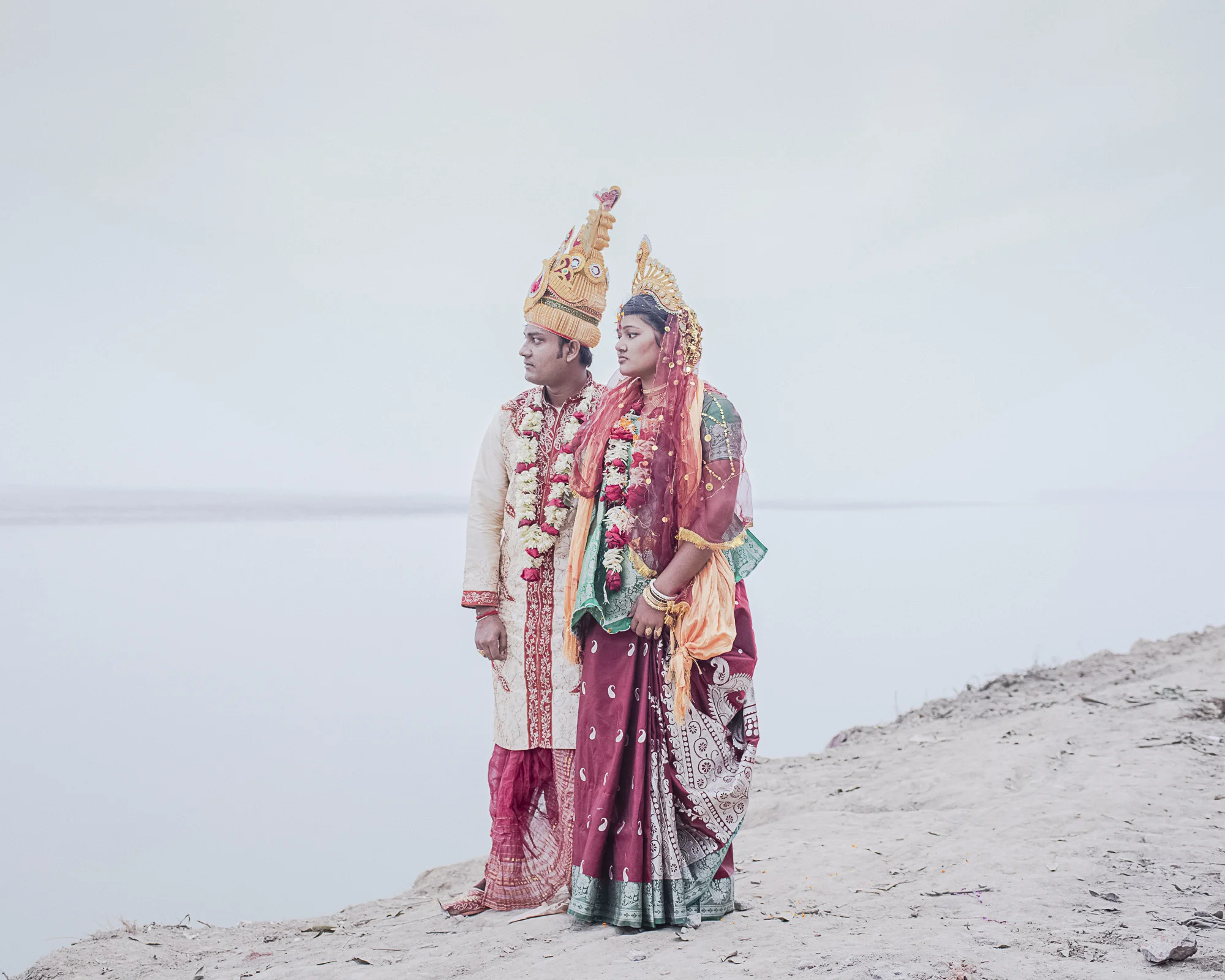 Leen / Jirno / Awngar by Sarker Protick, photographed by Sarker Protick — A solitary figure stands atop eroded white clay cliffs overlooking a flat, misty body of water.