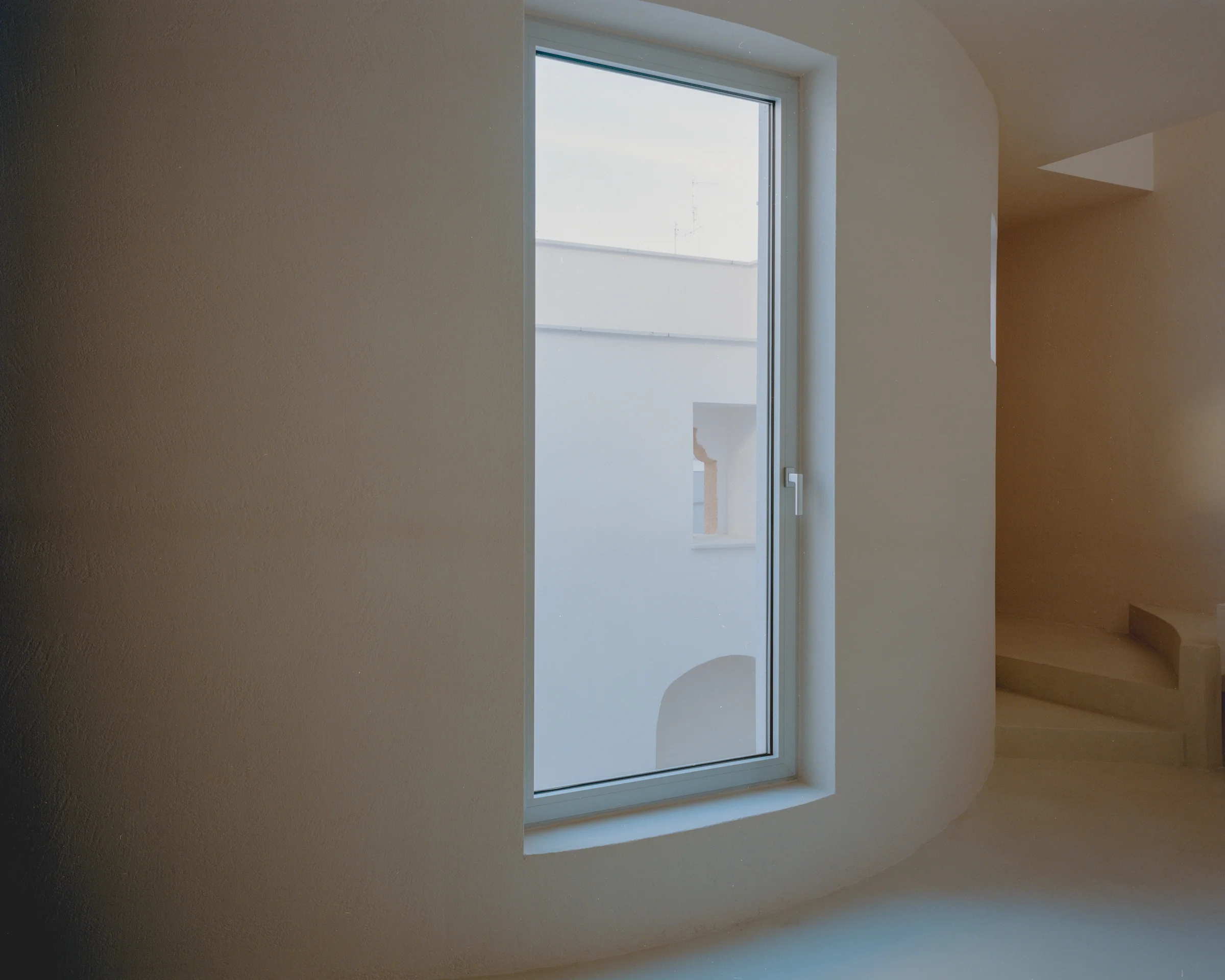 Casa Verri by Giovanni Rucci, photographed by Federico Farinatti — A street-level view of Triggiano's dense urban fabric, where the Casa Verri renovation sits within a closely-packed neighborhood of early 20th-century buildings.