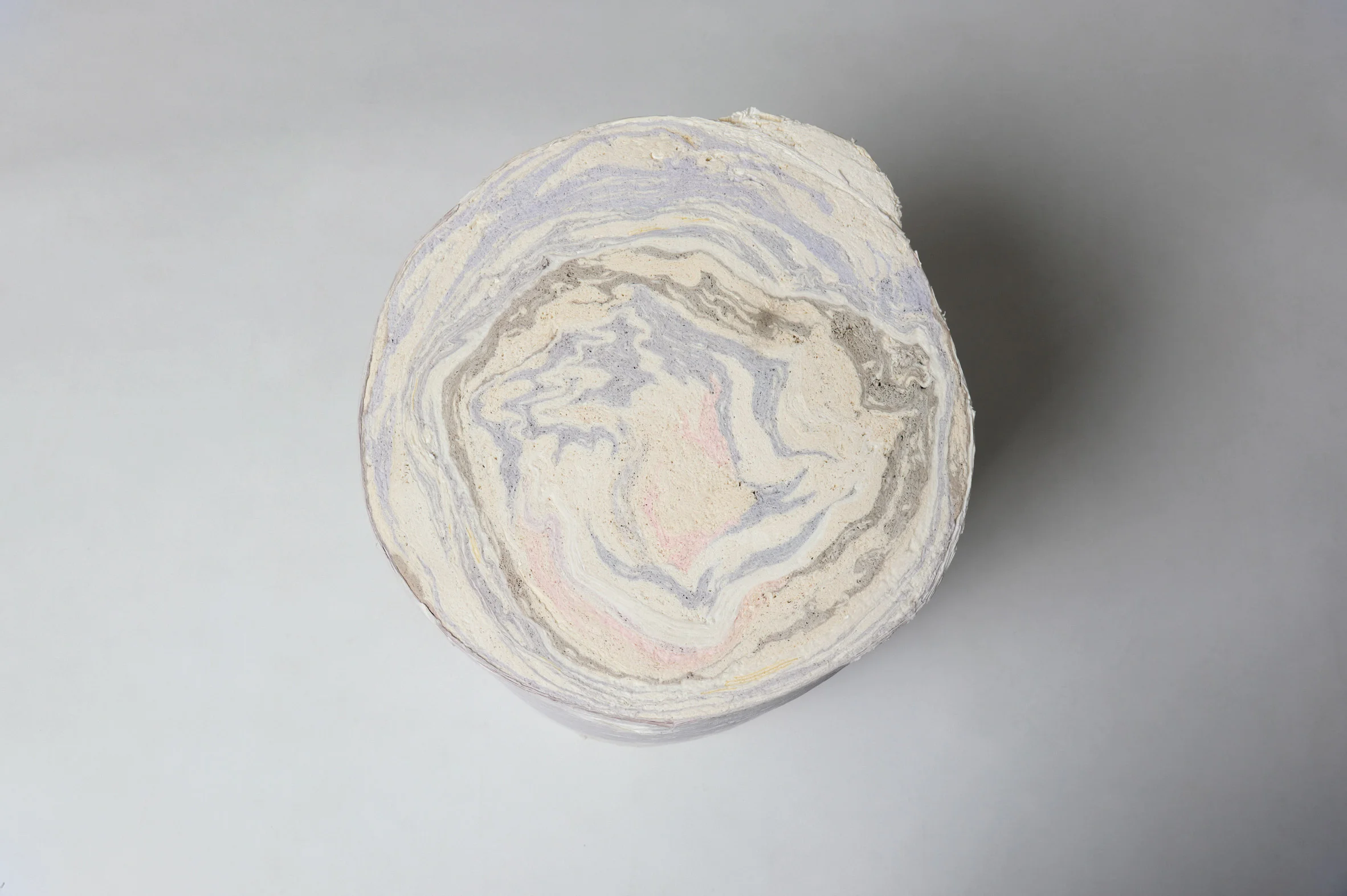 The Paper Log: Shell and Core by Issey Miyake + Ensamble Studio, photographed by Courtesy Issey Miyake — Close-up detail of a sculptural paper furniture element showing compressed layers of pleated waste material from garment production.