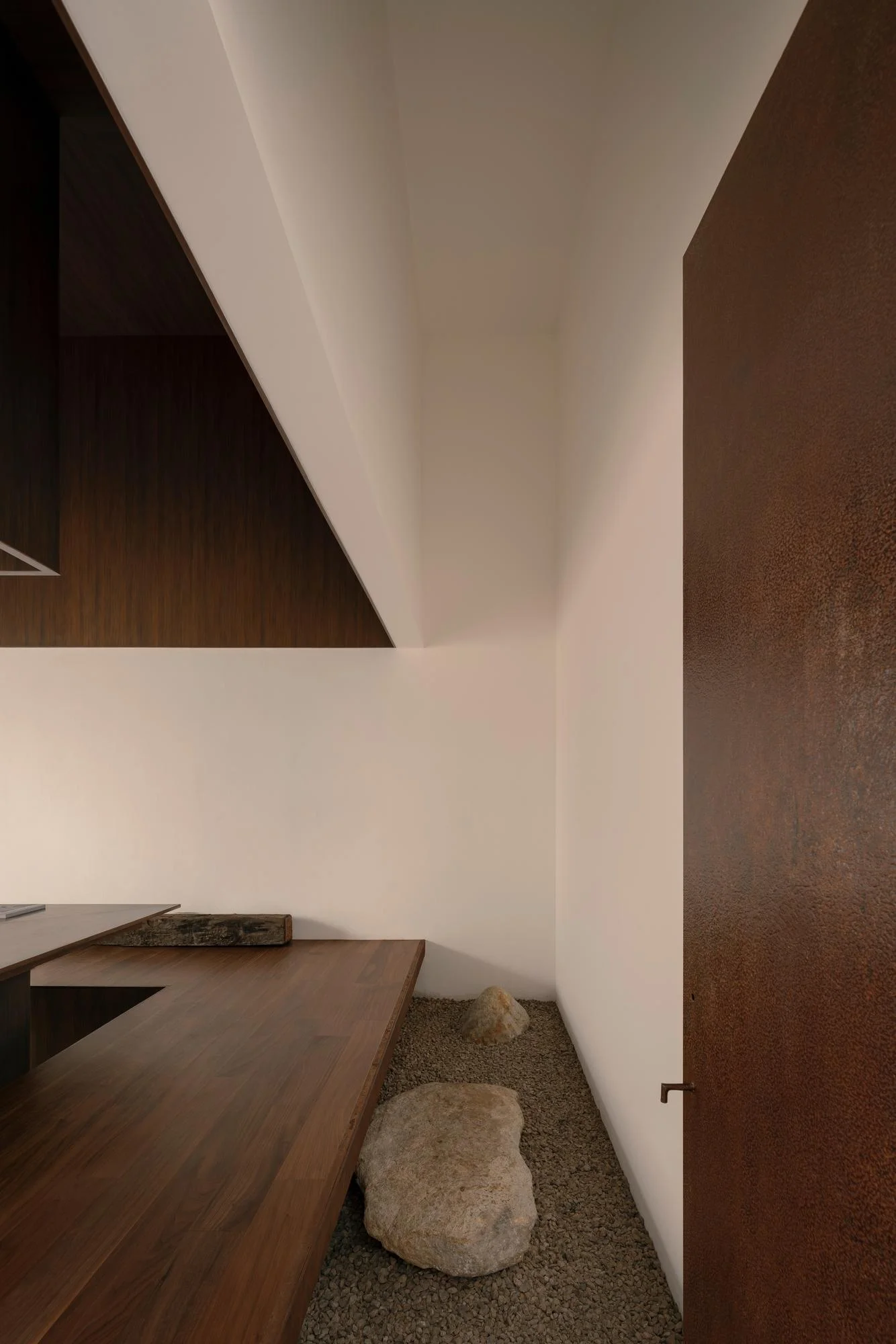 Kehai House by HW Studio, photographed by César Béjar, Gustavo Quiroz — A single ovoid stone rests on fine gravel within a rectangular wooden-framed sand garden, centered in a minimalist interior space.