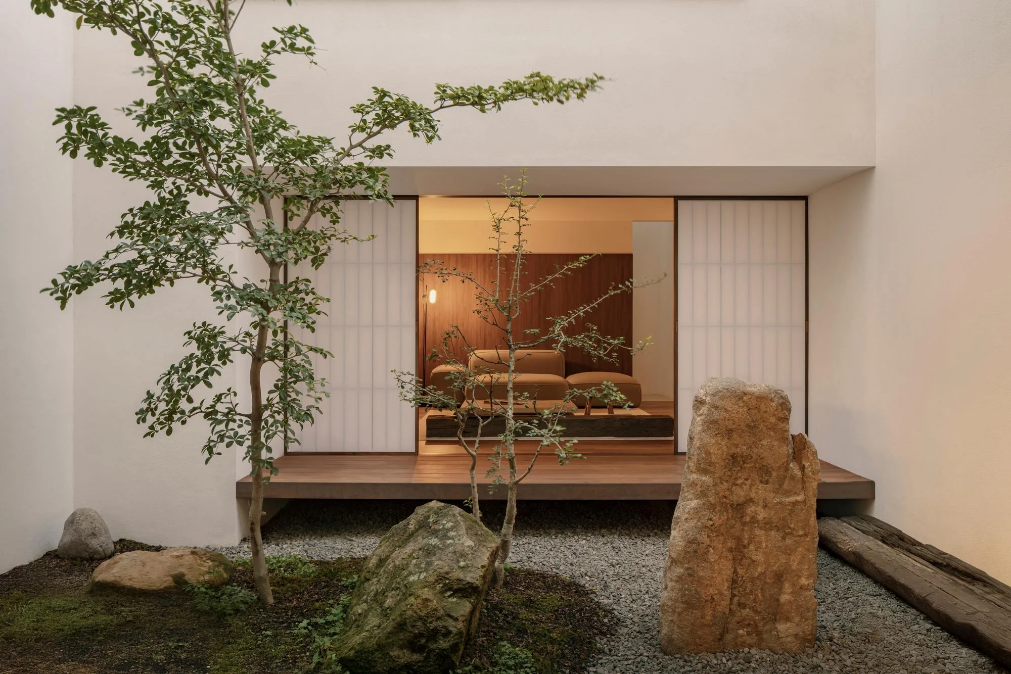 Kehai House by HW Studio, photographed by César Béjar, Gustavo Quiroz — A narrow interior courtyard frames a central planting arrangement viewed from an elevated threshold.