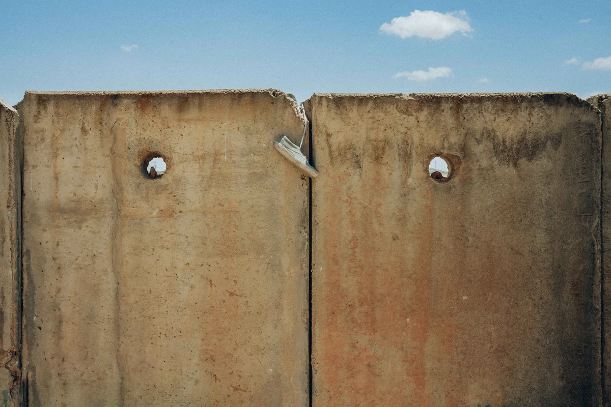 Landing by Maen Hammad, photographed by Maen Hammad — Three Palestinian skateboarders occupy a multi-level wooden structure in the West Bank, each positioned at different heights within the composition.
