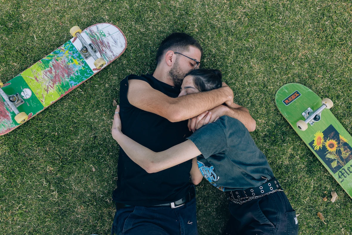 Landing by Maen Hammad, photographed by Maen Hammad — A brown horse with blue halter stands tethered against weathered concrete barriers in an open lot.
