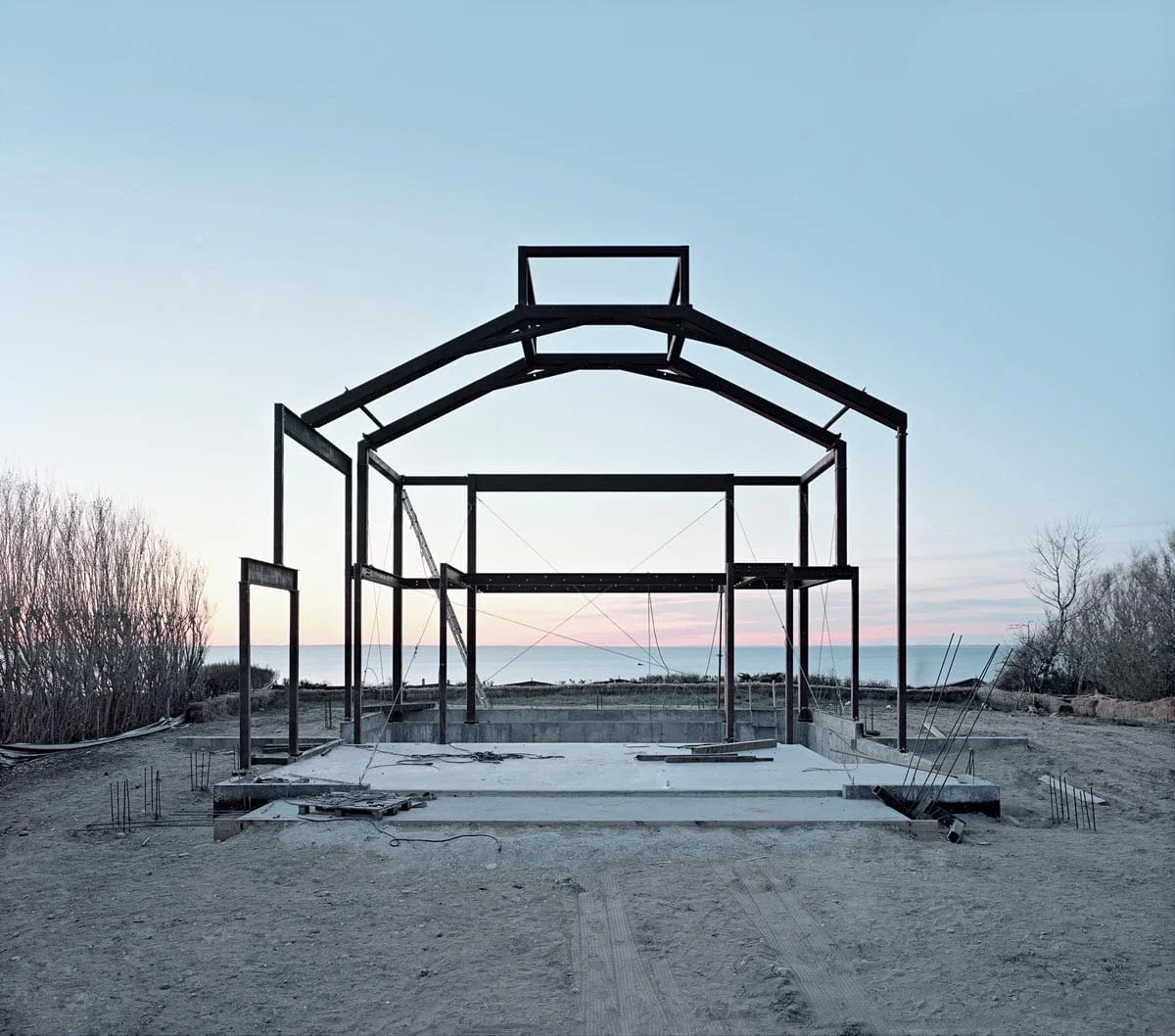 National Character by John Sanderson, photographed by John Sanderson — A large yellow articulated dump truck dominates the foreground of this open-pit mining operation in rural Pennsylvania, positioned on a grass staging area adjacent to an active excavat