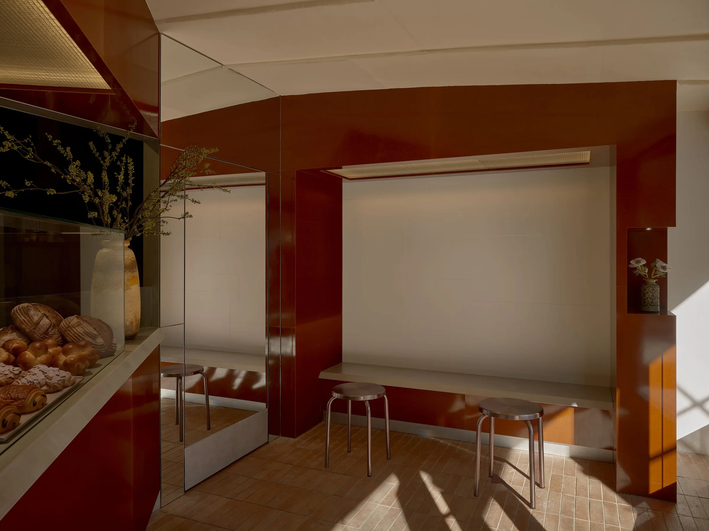 Diljān Afghan Bakery by New Body, photographed by Sean Davidson — A ceramic vessel sits centered on a cream-colored display shelf within a glass enclosure.