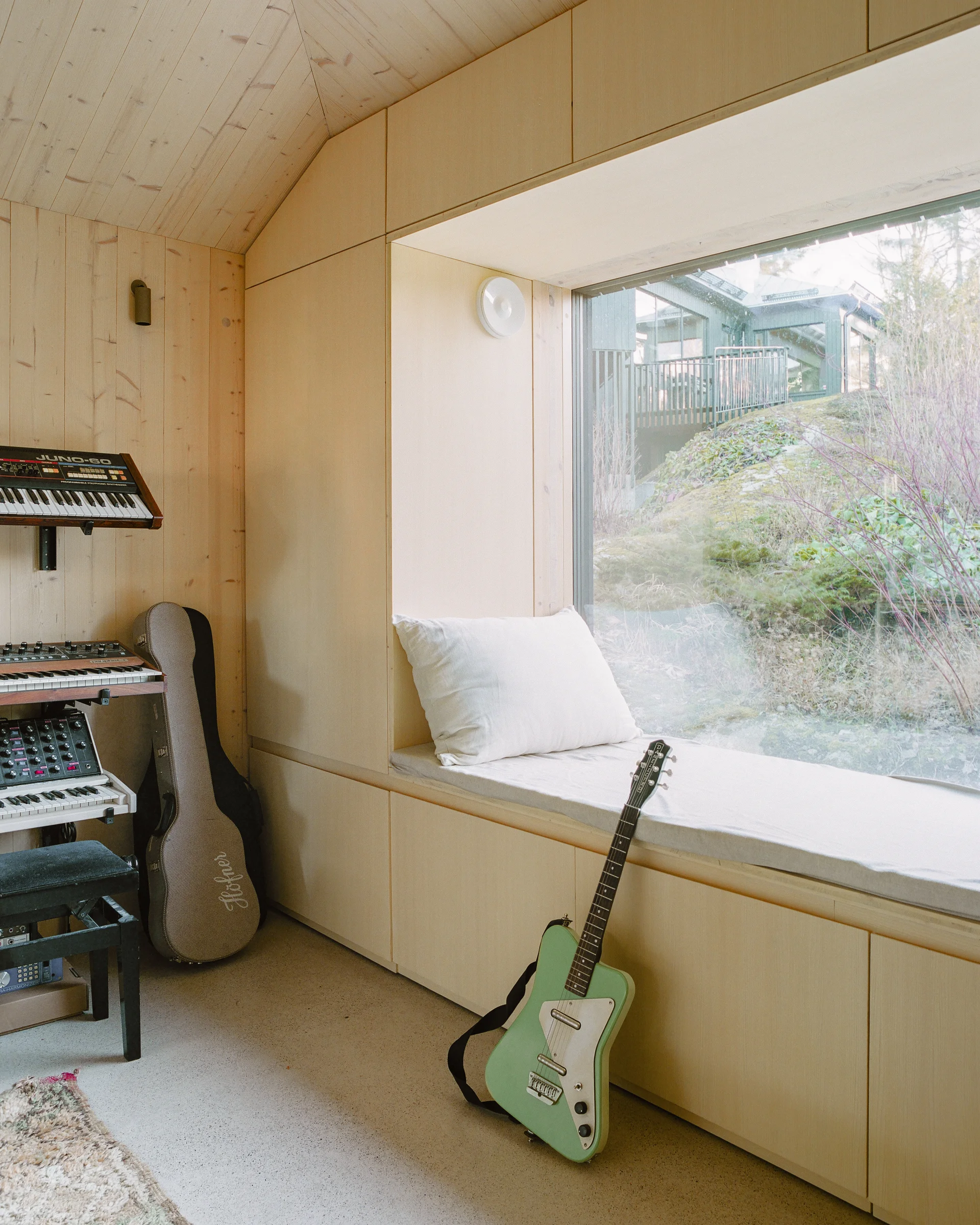 Villa Margo by Talli Ark, photographed by Kalle Kouhia — Villa Margo's garden music studio presents a compact volumetric form clad in dark-green vertical timber boarding.