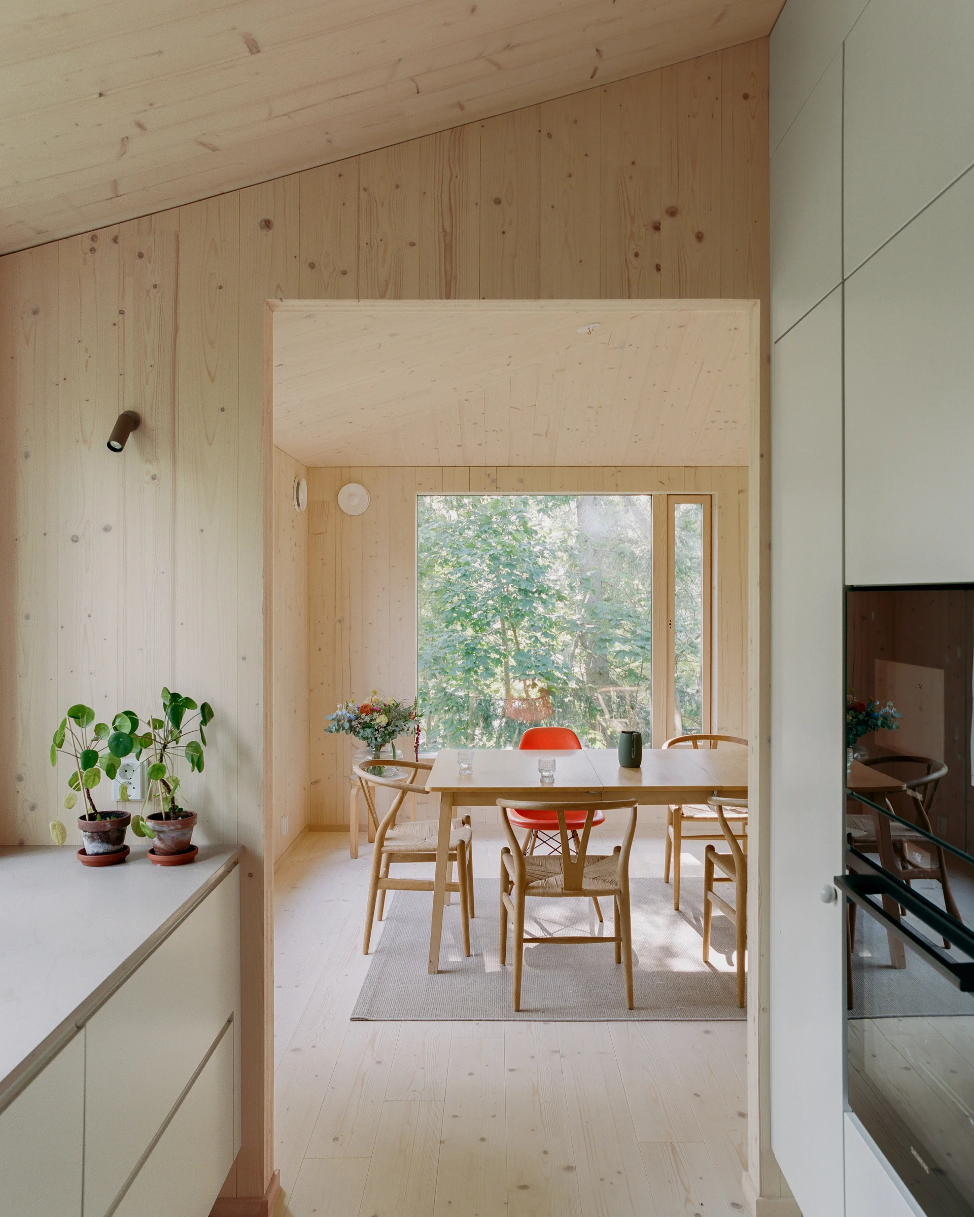 Villa Margo by Talli Ark, photographed by Kalle Kouhia — A garden studio interior with pine-boarded walls and ceiling featuring knots and natural grain variation.