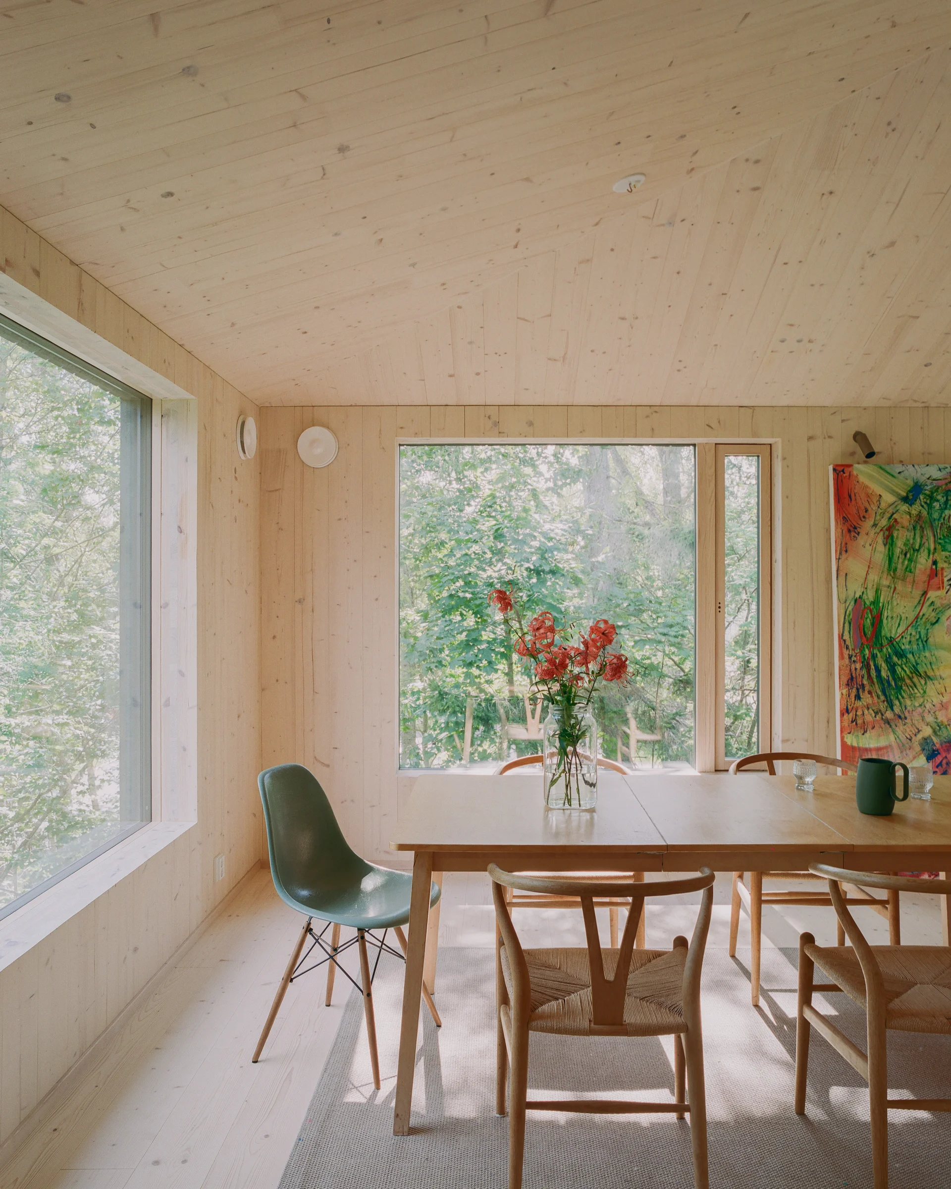 Villa Margo by Talli Ark, photographed by Kalle Kouhia — A music studio interior within Villa Margo's garden building features a built-in window seat aligned with large glazing overlooking the hillside landscape.