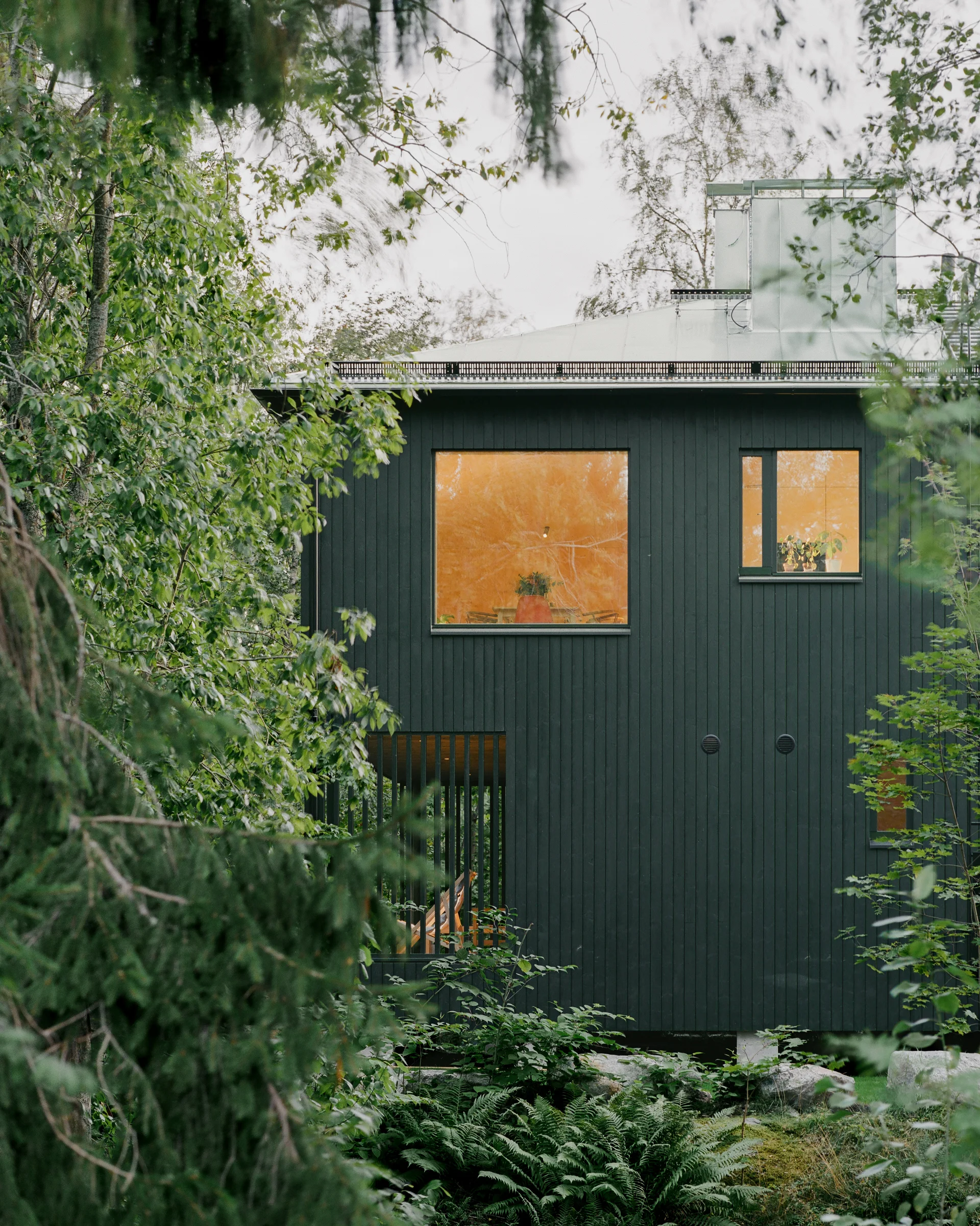 Villa Margo by Talli Ark, photographed by Kalle Kouhia — Interior view of Villa Margo's open-plan living space, characterized by exposed pine timber cladding on walls and vaulted ceiling.