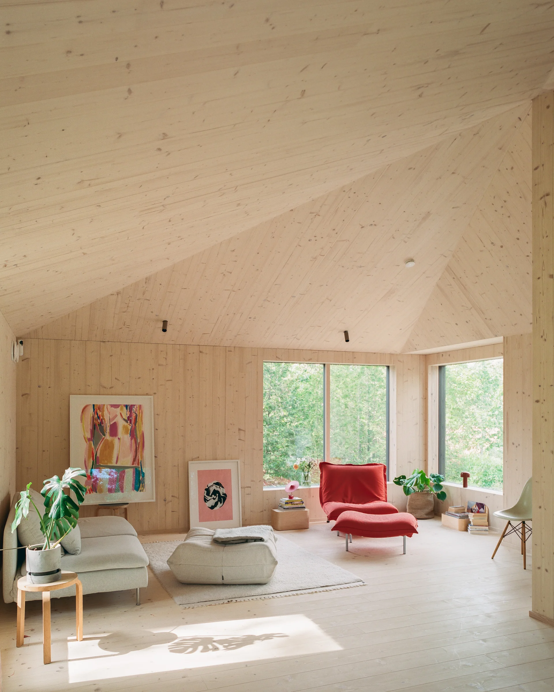 Villa Margo by Talli Ark, photographed by Kalle Kouhia — Villa Margo's entrance presents a layered threshold composition: a timber staircase in warm oak ascends from a paved ground level toward a dark-green corrugated metal facade.