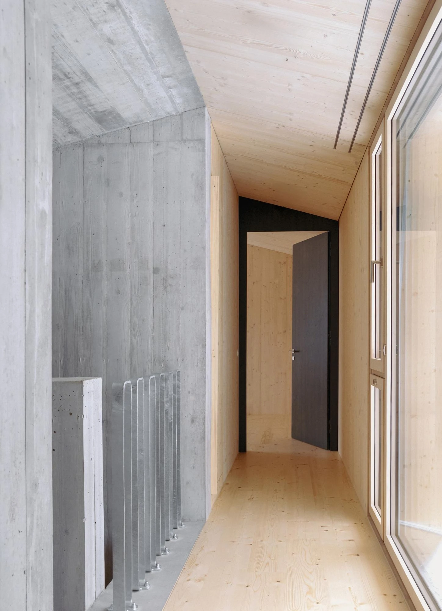 Tower House by kit, photographed by Till Forrer — Detail of the spruce external corner: boards wrapping precisely around the edge with tight mitre joint and an open shadow gap.
