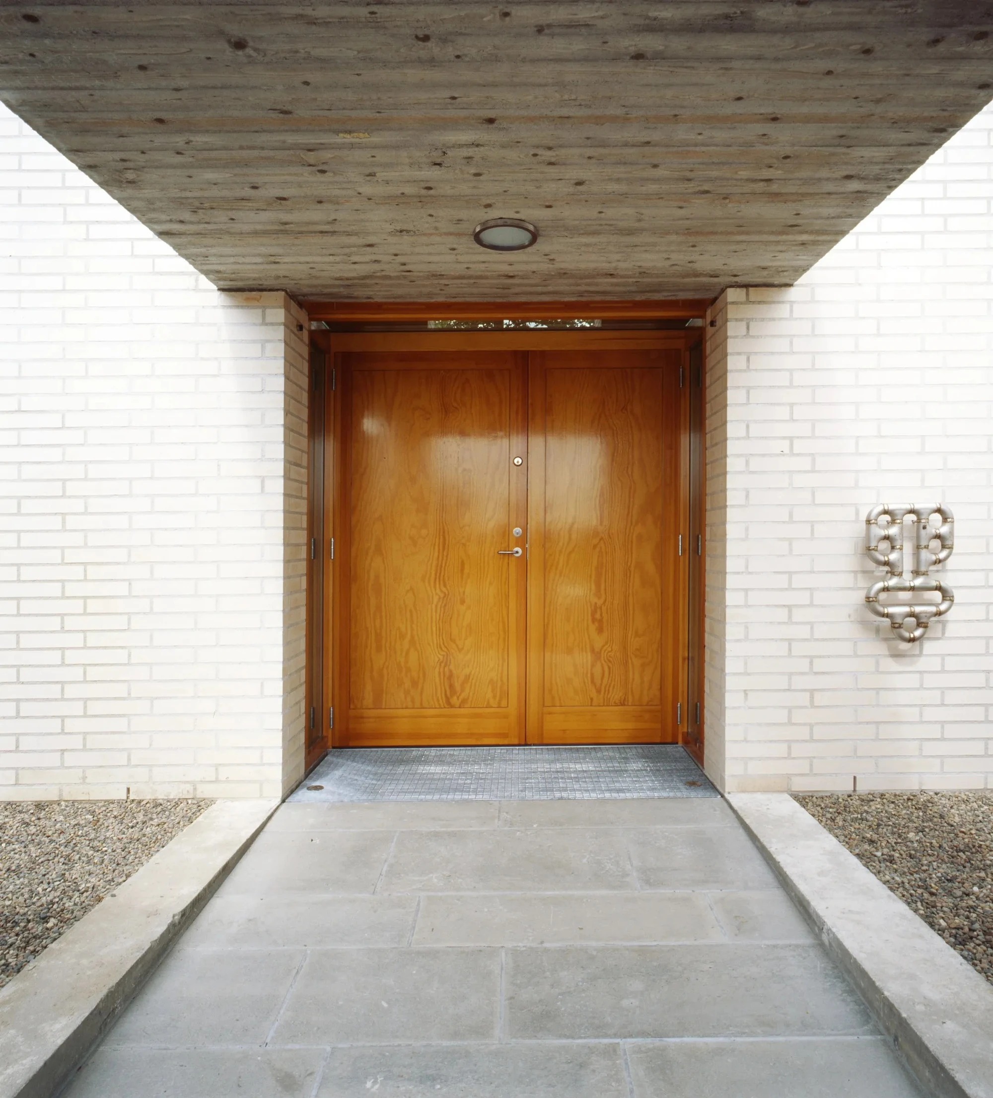 Mortuary at Asker Crematorium by Carl-Viggo Hølmebakk AS, photographed by Carl-Viggo Hølmebakk, Per Berntsen, Nils Petter Dale, Jiri Havran — Preparation room interior: stainless steel table, rectangular skylight, white brick at the base of the walls, ...