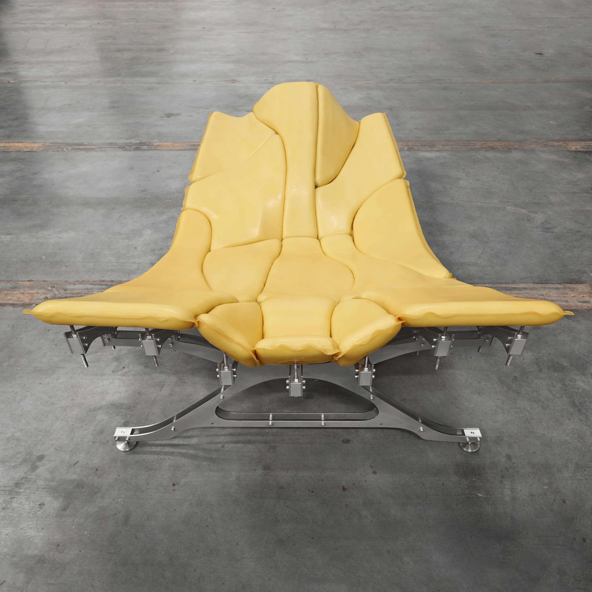 Daydreamer by onlyonly.studio, photographed by onlyonly studio — Daydreamer at a low angle: the eight stainless steel legs visible under the latex body, precision hardware at each floor contact, the form hovering above a polished concrete surface.