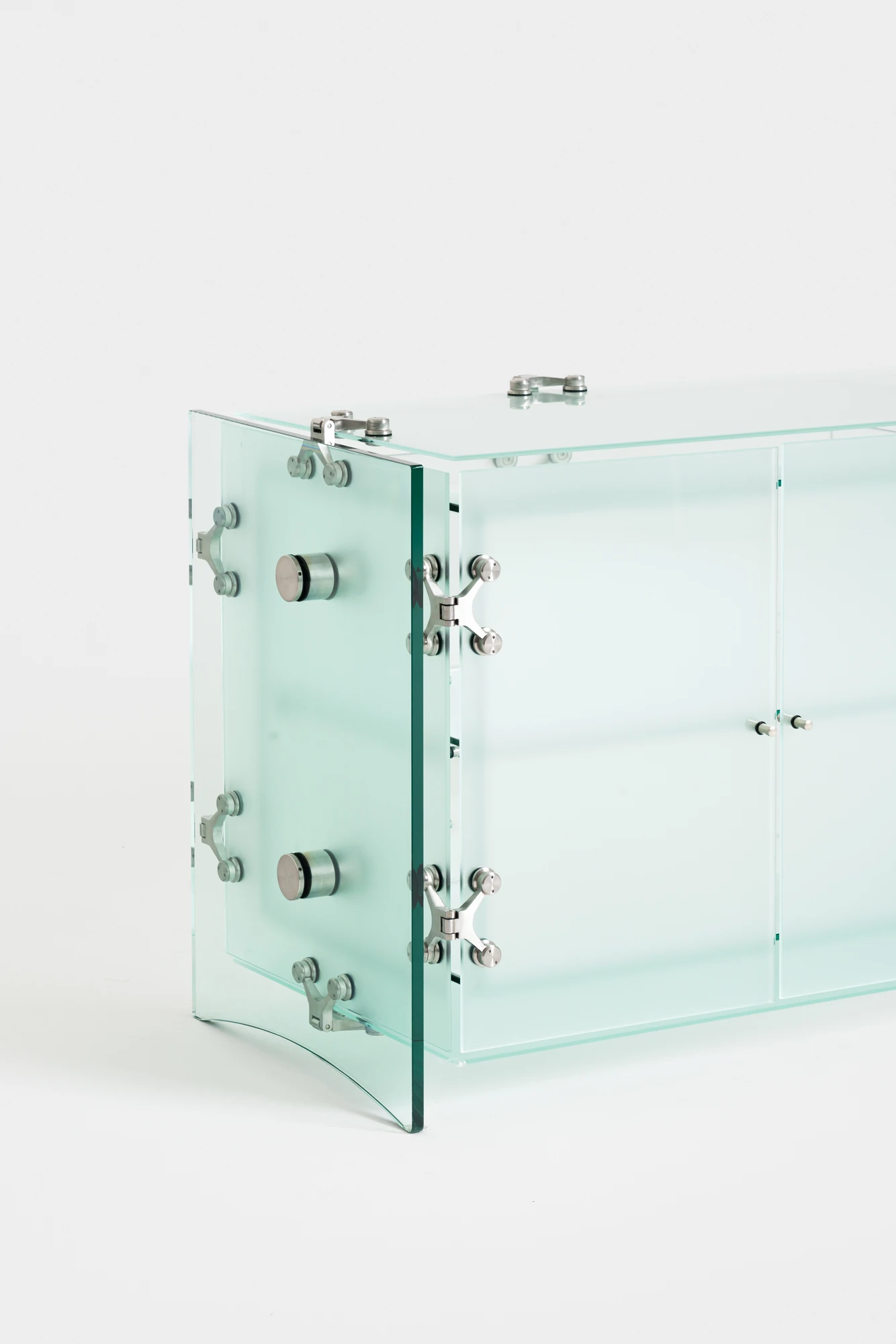 Ferric Glass by Tino Seubert, photographed by Piercarlo Quecchia, DSL Studio — Detail of the table lamp hardware from the side: coil spring connector and spider arm visible, the glass panels meeting at the join with precise tolerances.