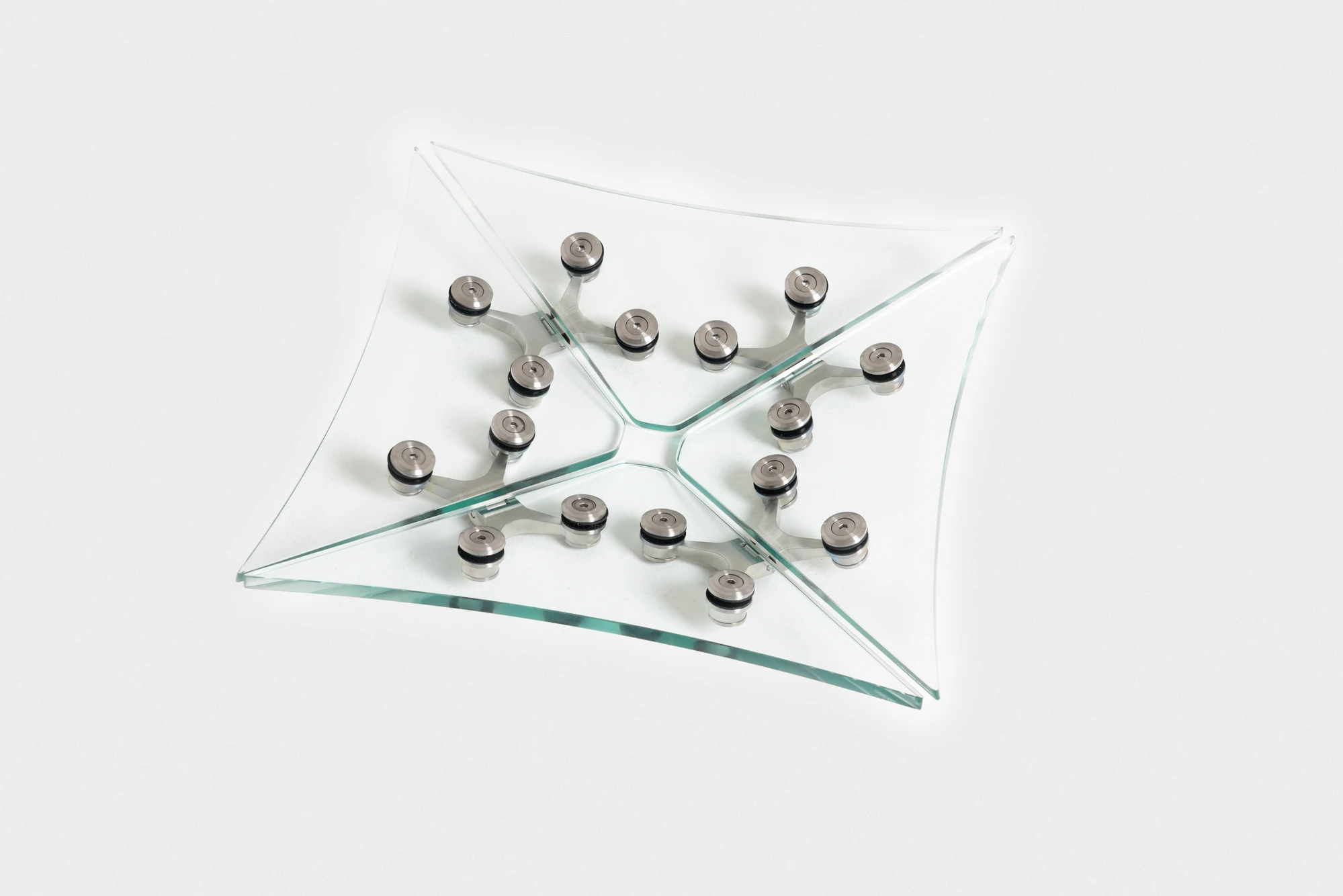 Ferric Glass by Tino Seubert, photographed by Piercarlo Quecchia, DSL Studio — The glass sideboard from above: clear and frosted panels form the top surface, the spider hinges arranged at regular intervals along the length.