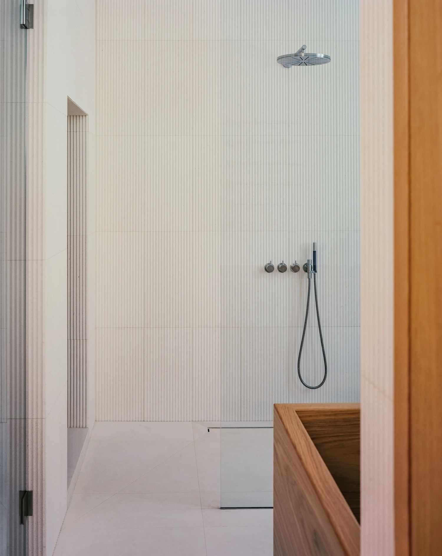 Panoramic House by MATA Architects, photographed by Nick Dearden — Side hall detail showing the transition between original house and extension: oak panelling, the step change in floor level, and garden visible through glass.