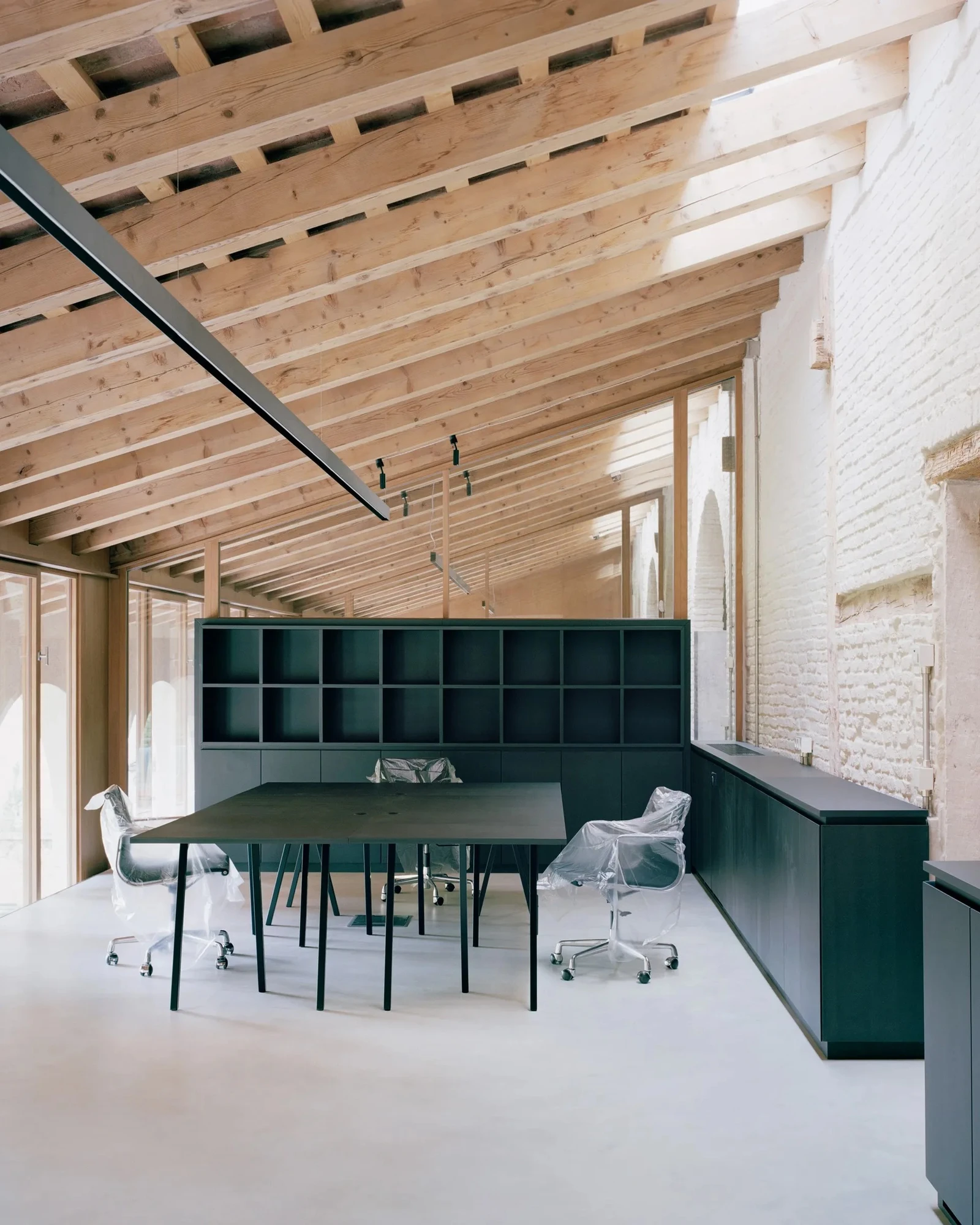 Vis-à-vis Restoration of Villa Doná and Barchessa by RigonSimonetti, photographed by Rory Gardiner, Alberto Sinigaglia — Cafe interior from above: the double-height space with whitewashed brick and exposed timber rafters, okoume counter and vestibule…