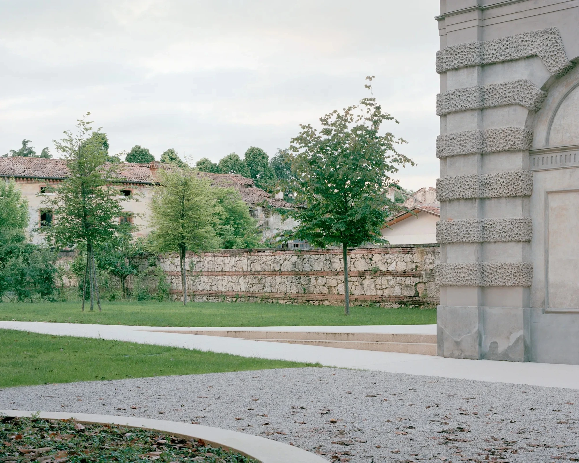 Vis-à-vis Restoration of Villa Doná and Barchessa by RigonSimonetti, photographed by Rory Gardiner, Alberto Sinigaglia — Interior threshold: a new oak door frame set into a rough lime-washed masonry wall, a recovered fanlight arch with radial tracery…
