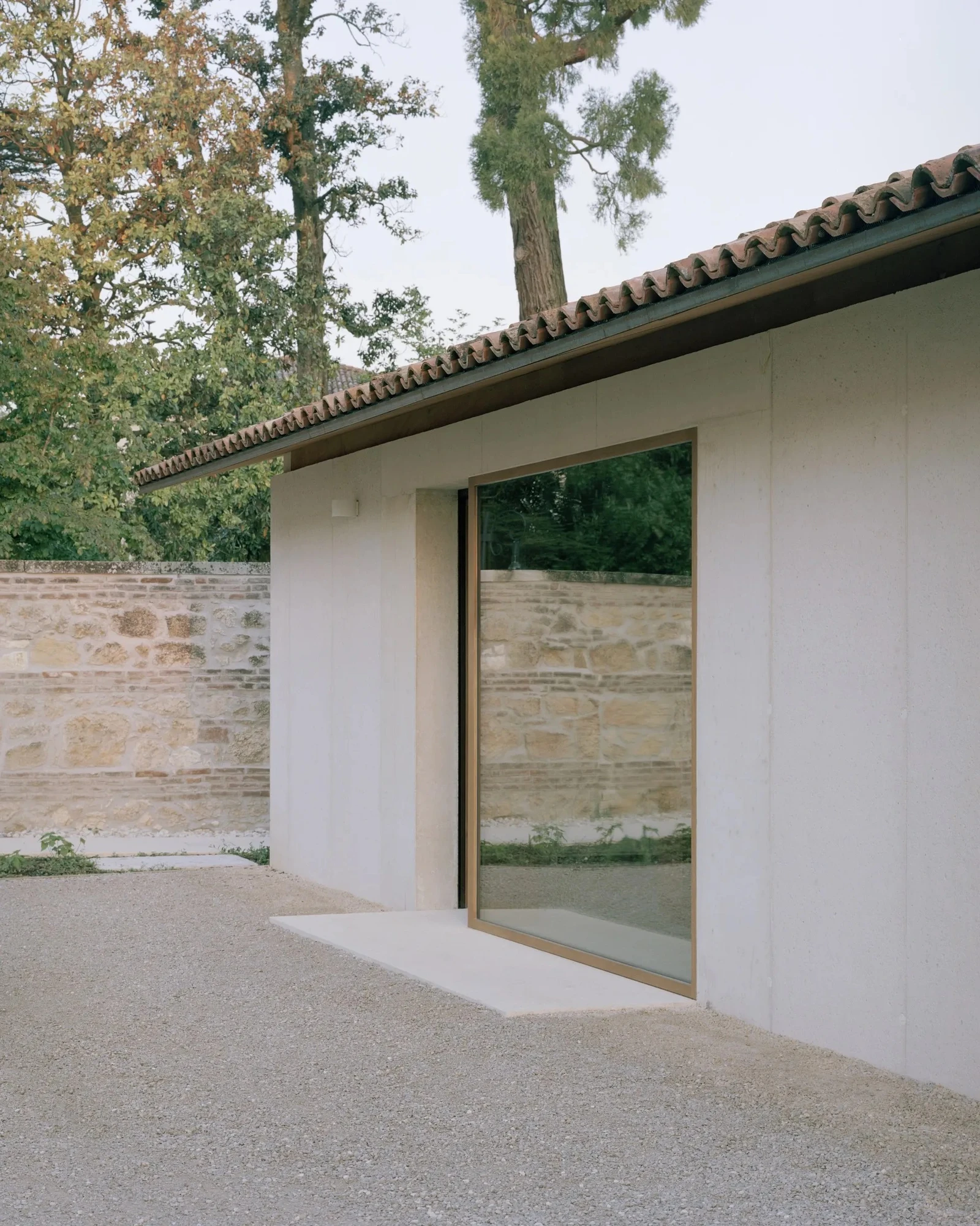 Vis-à-vis Restoration of Villa Doná and Barchessa by RigonSimonetti, photographed by Rory Gardiner, Alberto Sinigaglia — Cafe seating area: whitewashed brick arches, built-in okoume benches, a glazed vestibule volume sitting within the historic envelope…