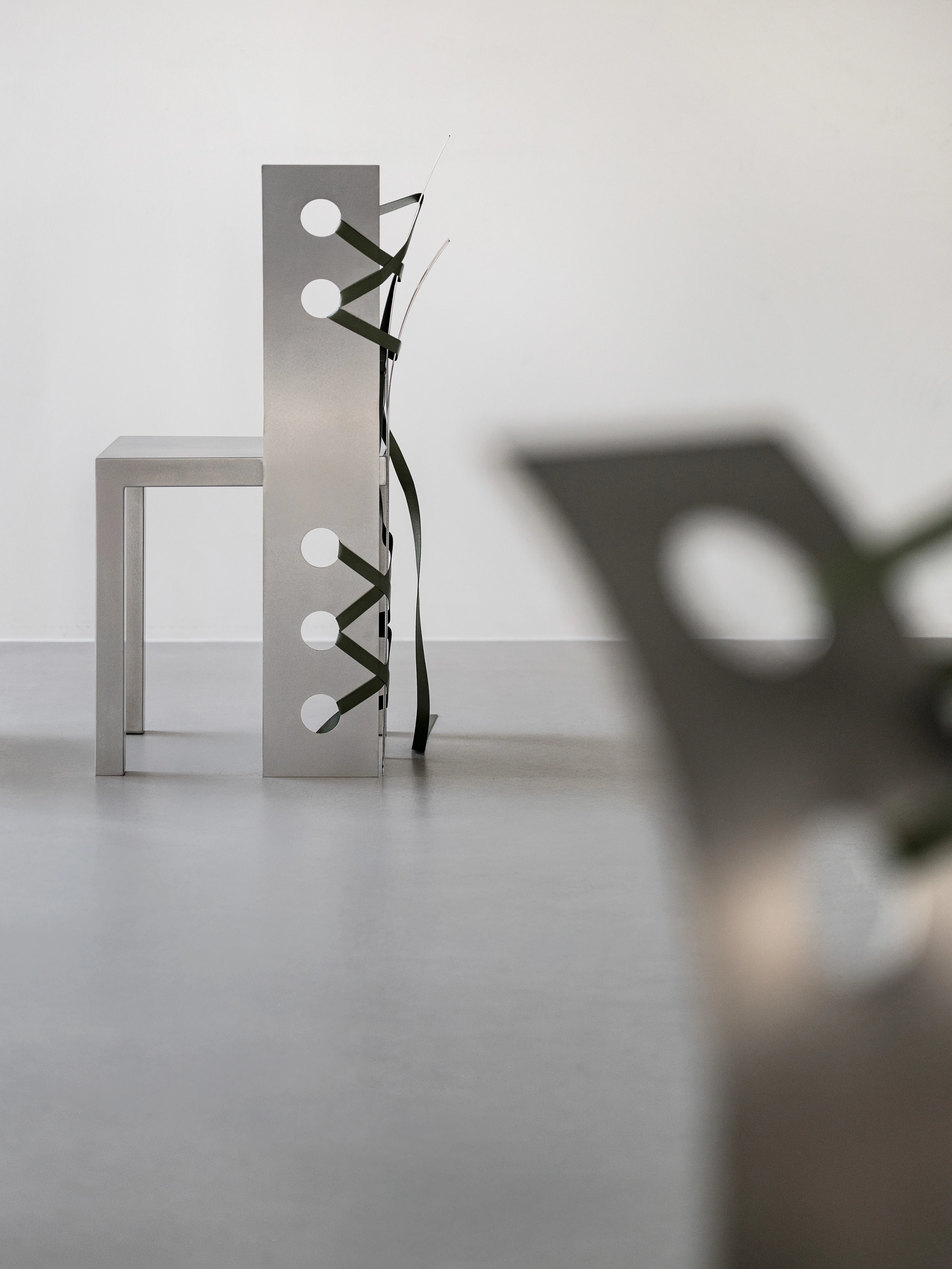 Pul Collection by Nara Lee, photographed by Namuk Kim — Wider exhibition shot showing chairs, benches, and screens together under directed spotlights.