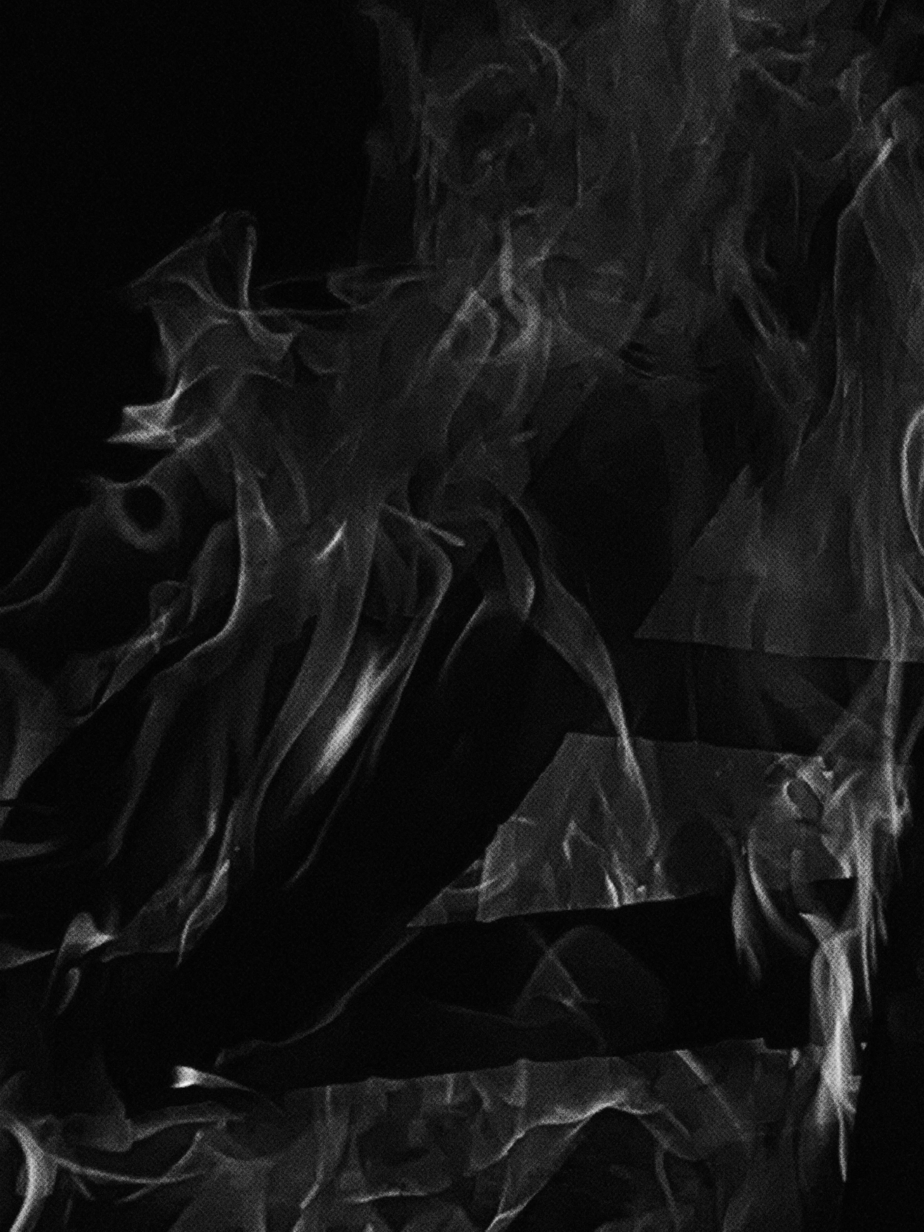Same Dialect of Different Languages by Antonia Mayer, photographed by Antonia Mayer — Abstract study of pale fire or smoke-like fabric folds in extreme macro, almost entirely black.