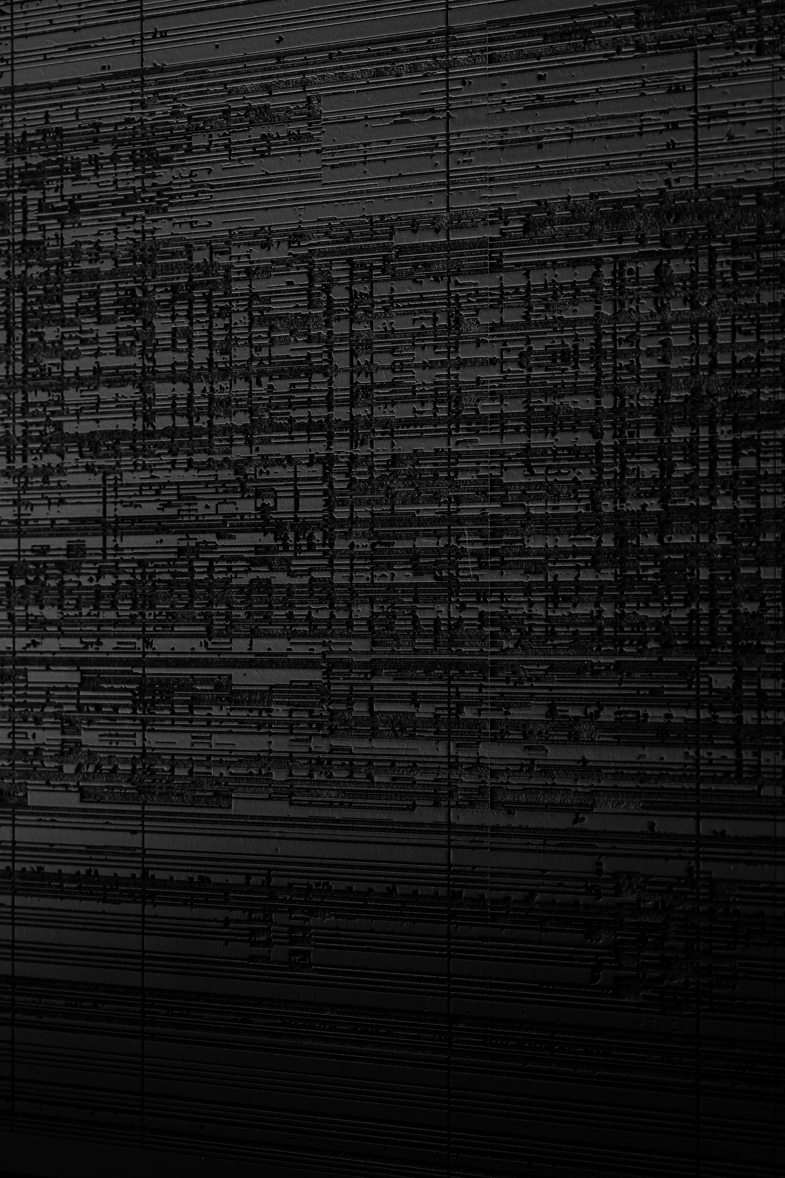 Strange Rules by Mat Dryhurst, Holly Herndon, Hans Ulrich Obrist, Adriana Rispoli — Macro surface detail of a large black panel showing a dense compressed grid of horizontal and vertical marks, data-like patterning that reads as both textile grain and…