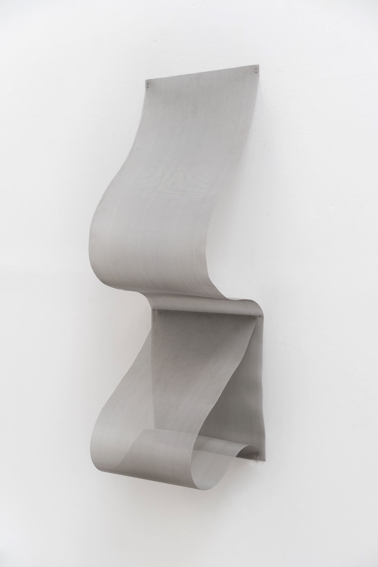 Main de fer, gant de velours by Agurto + Fiedler, photographed by Katherinne Fiedler — Caudal by Katherinne Fiedler, full view of stainless steel mesh forming continuous S-curve, translucent woven surface undulating from wall.