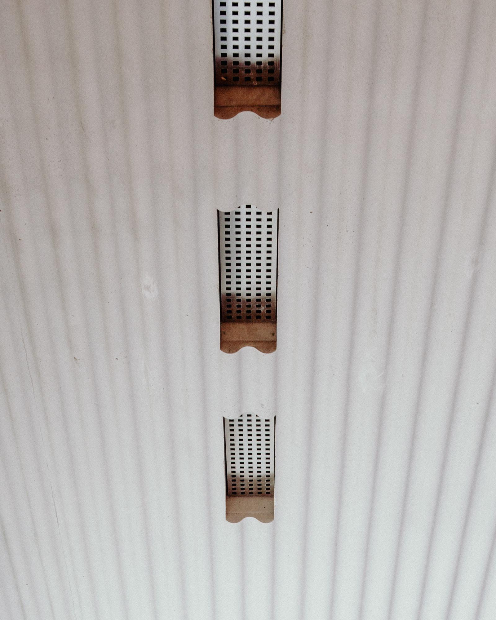 Xavier Hufkens Gallery by Robbrecht en Daem Architecten, photographed by Jeremy Piret — Corrugated aluminum ceiling with rectangular perforated ventilation grilles aligned in a row, industrial rhythm.