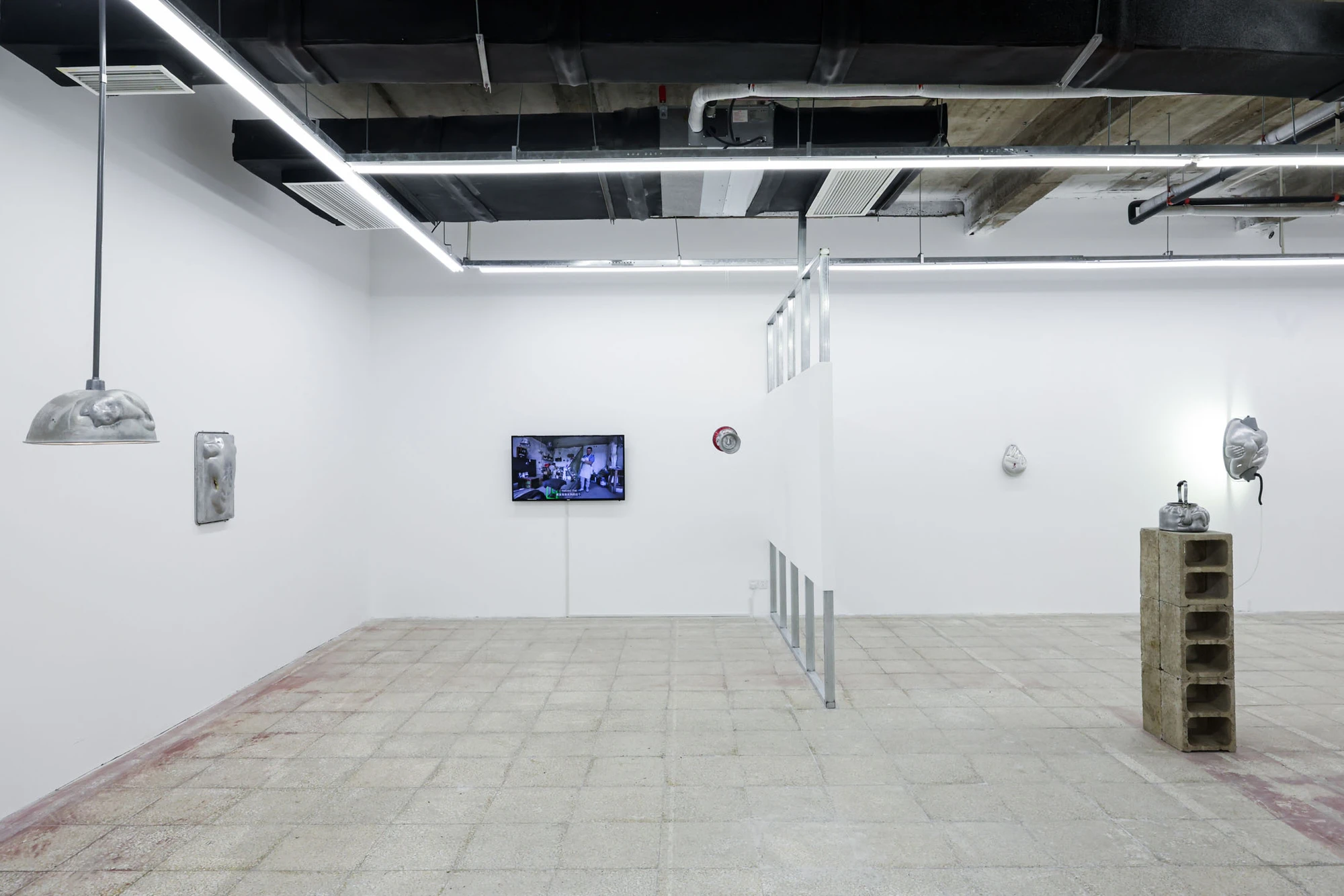A User Guide by Tian Jianxin, photographed at Capsule — two ladle-bowls suspended from a metal coat hanger read as a torso suspended in front of an ivy-covered window.