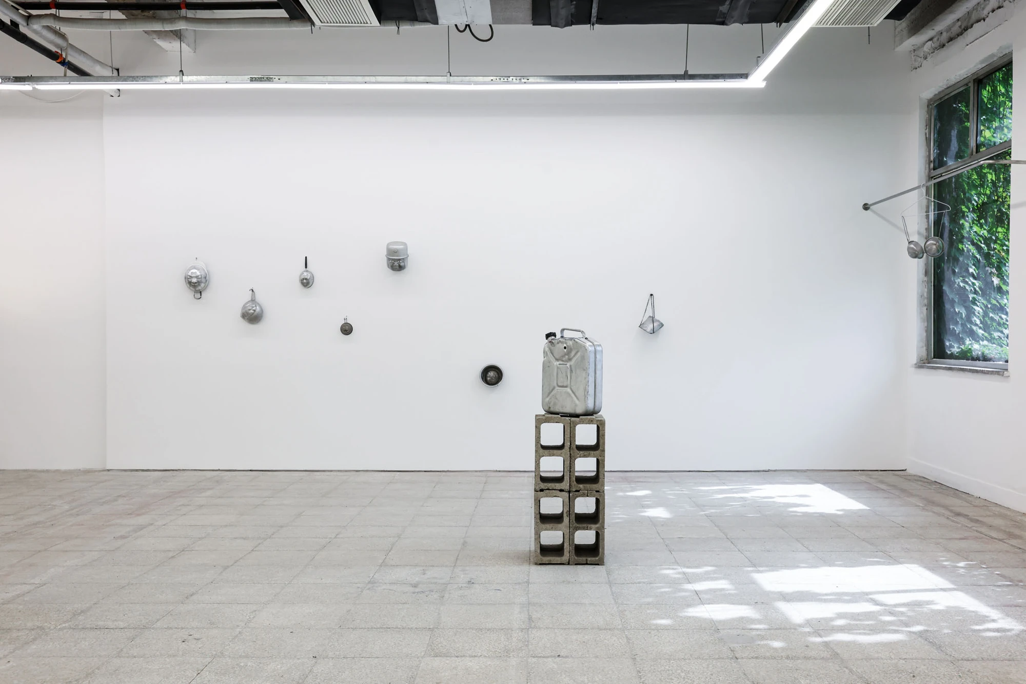 A User Guide by Tian Jianxin, photographed at Capsule — a small hammered dome anchors a partition wall, a stack of cinder blocks beside it carrying a single domestic vessel.