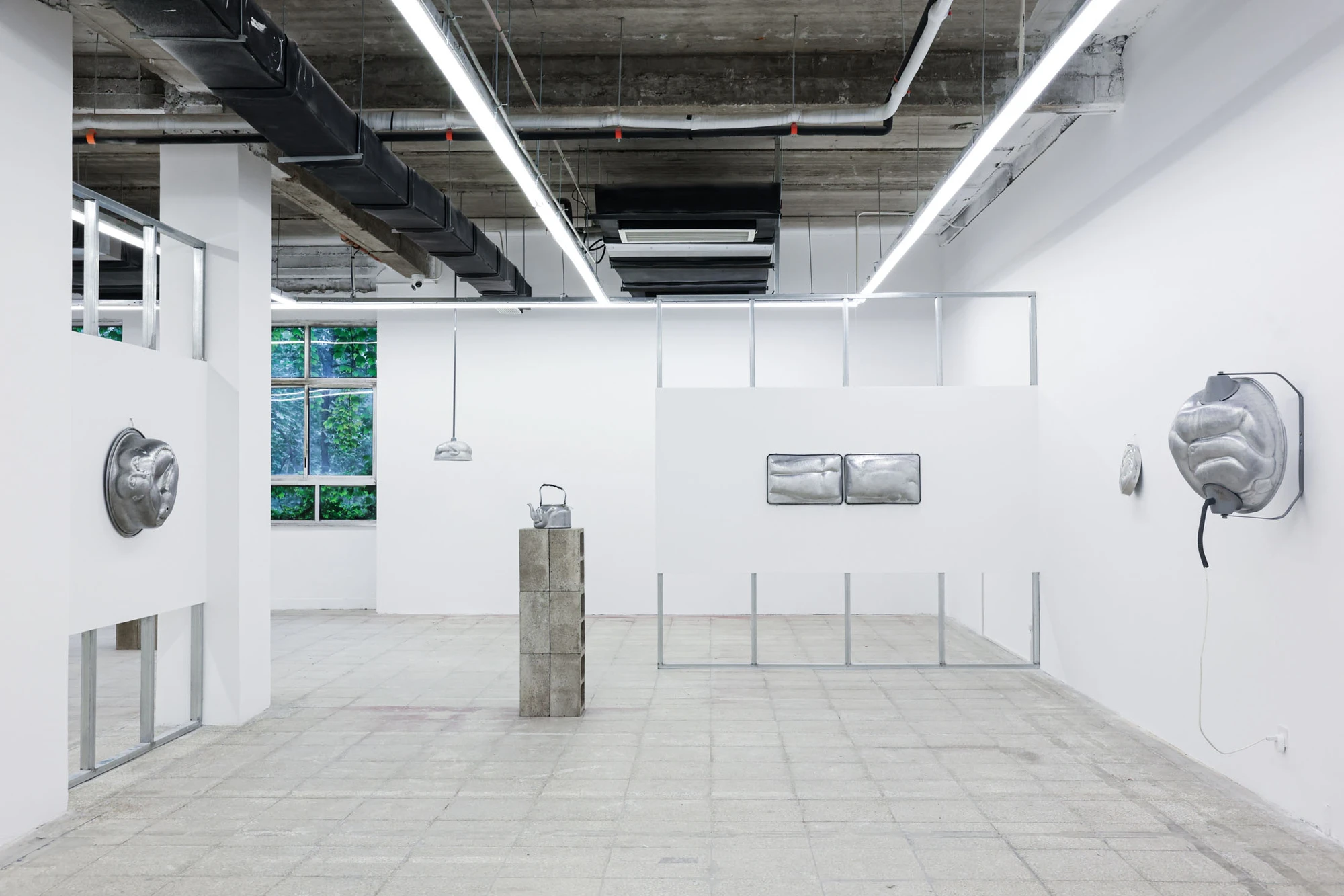 A User Guide by Tian Jianxin, photographed at Capsule — a clustered wall of hammered heads, a kettle-belly torso, and a dangling kitchen scoop reads like a row of folk icons.