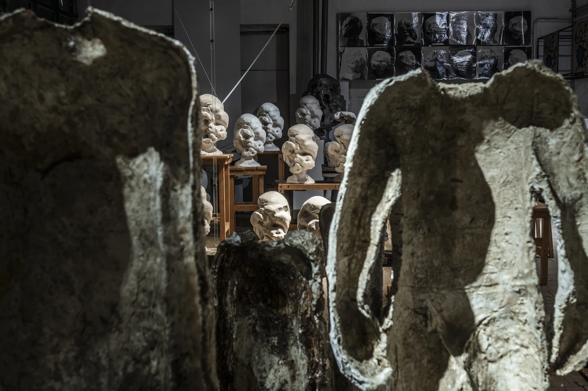 Magdalena Abakanowicz / Wanda Czełkowska by Abakanowicz Foundation, photographed by Norbert Piwowarczyk — Abakanowicz's tall plaster figures encircled by a thin metal line, Czełkowska's heads ranged behind on tables.