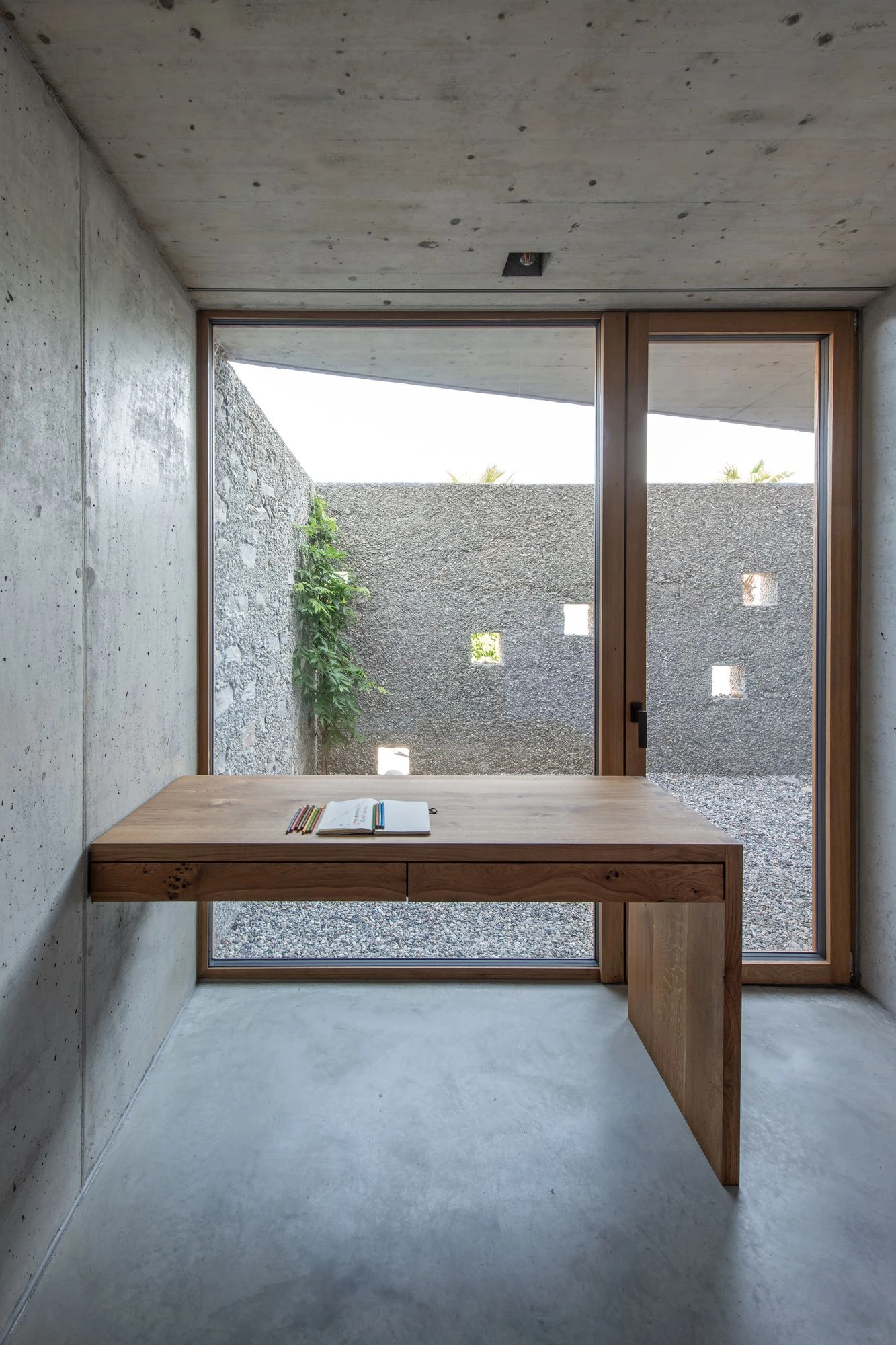 New House in San Nazzaro by Wespi de Meuron Romeo, photographed by Giacomo Albo — the polished concrete floor and aggregate side wall framing the seating area.
