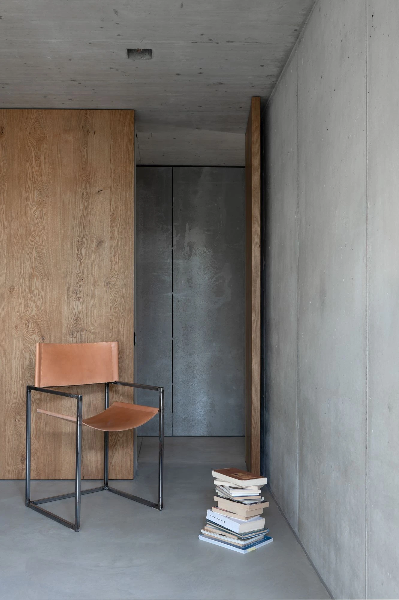 New House in San Nazzaro by Wespi de Meuron Romeo, photographed by Giacomo Albo — a bedroom landing where polished concrete meets the textured courtyard wall.