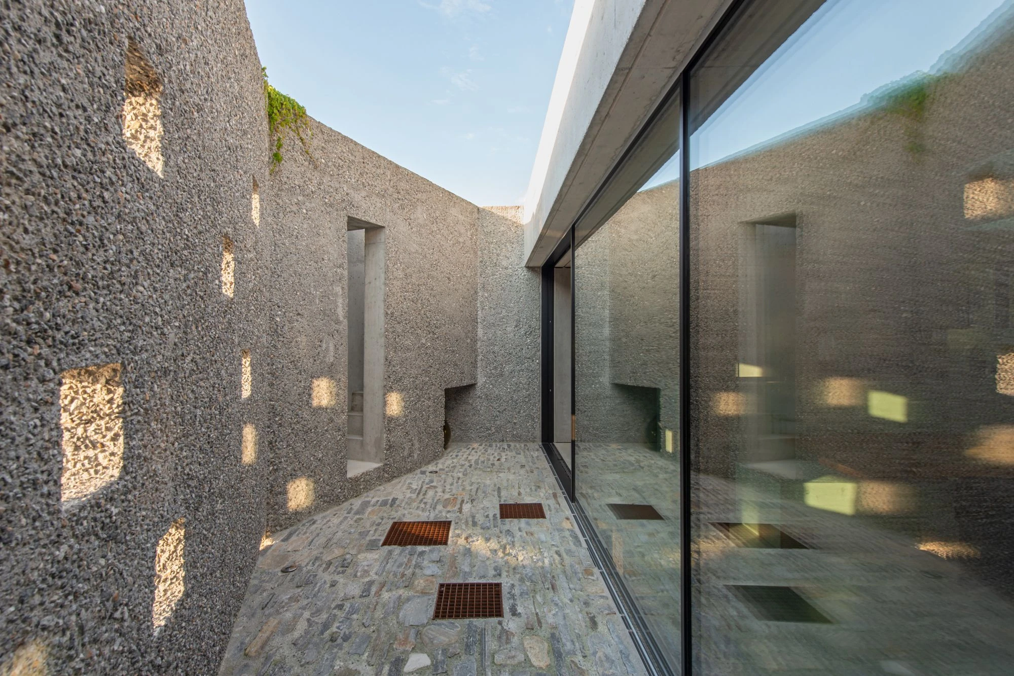 New House in San Nazzaro by Wespi de Meuron Romeo, photographed by Giacomo Albo — the cantilever and oak-framed glazing where the living space opens onto the lake-side court.