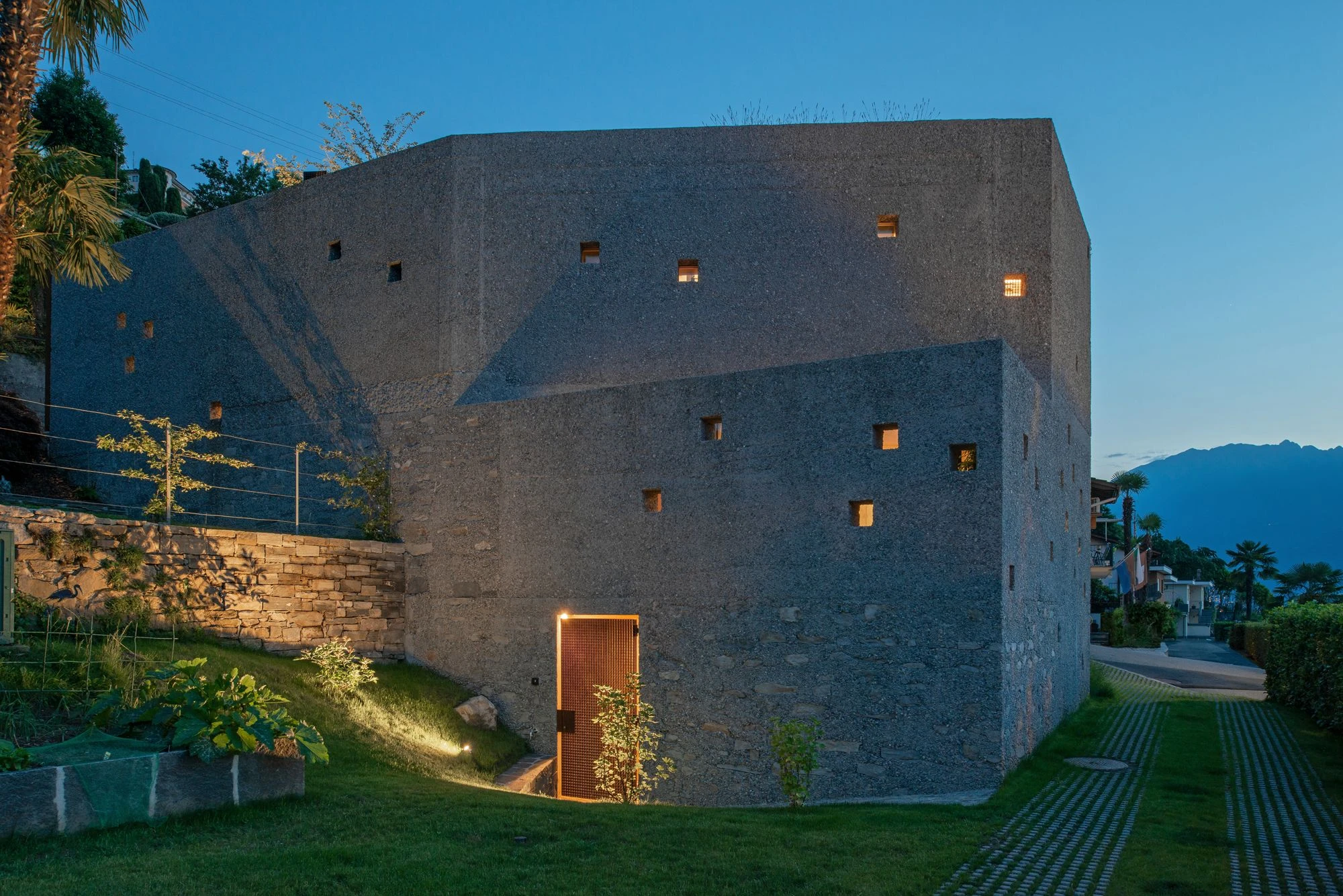 New House in San Nazzaro by Wespi de Meuron Romeo, photographed by Giacomo Albo — view from the living-dining room across the courtyard wall to the lake.