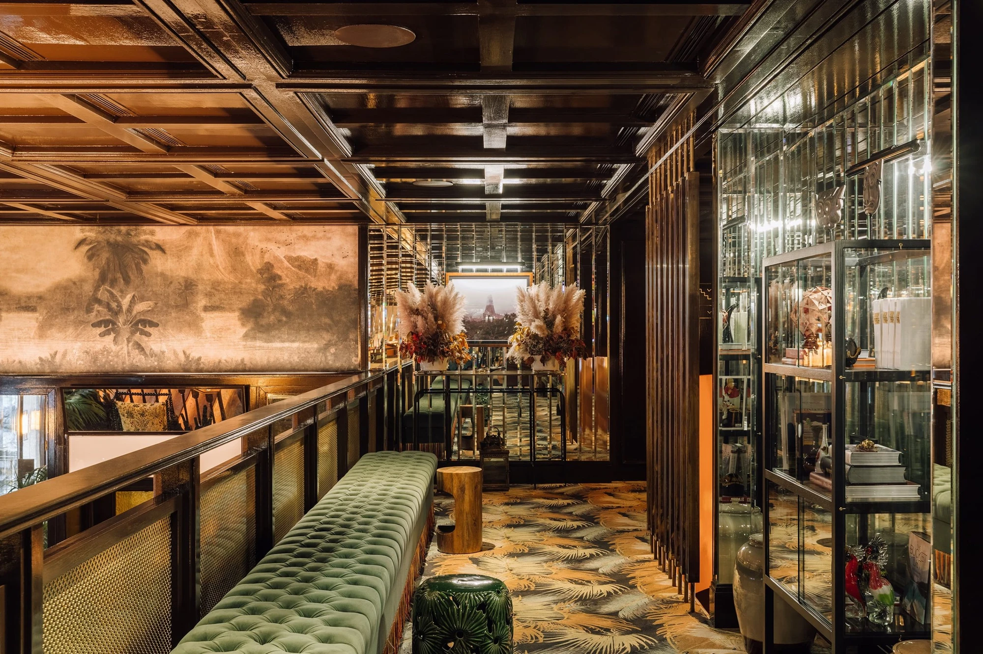 The Ivens by Lázaro Rosa-Violan, photographed by Francisco Nogueira — mezzanine bar with green velvet banquette, palm-frond floor and mirrored vitrines.