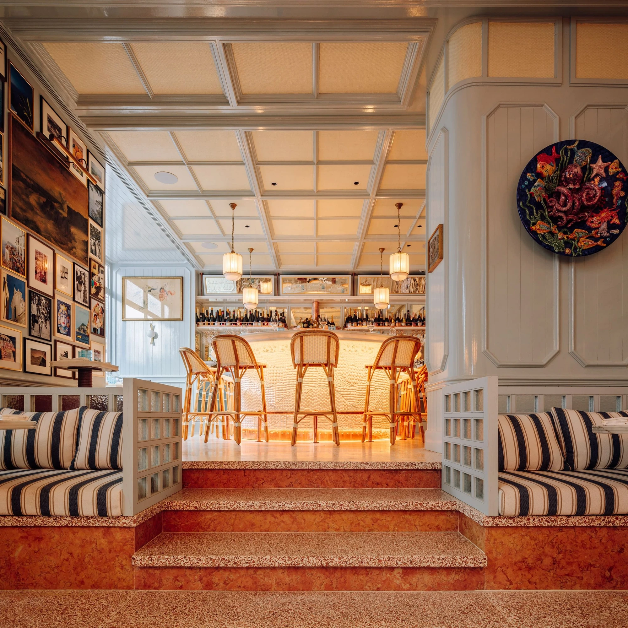 The Ivens by Lázaro Rosa-Violan, photographed by Francisco Nogueira — Rocco with striped banquettes, oxblood terrazzo steps and rattan-back bar.