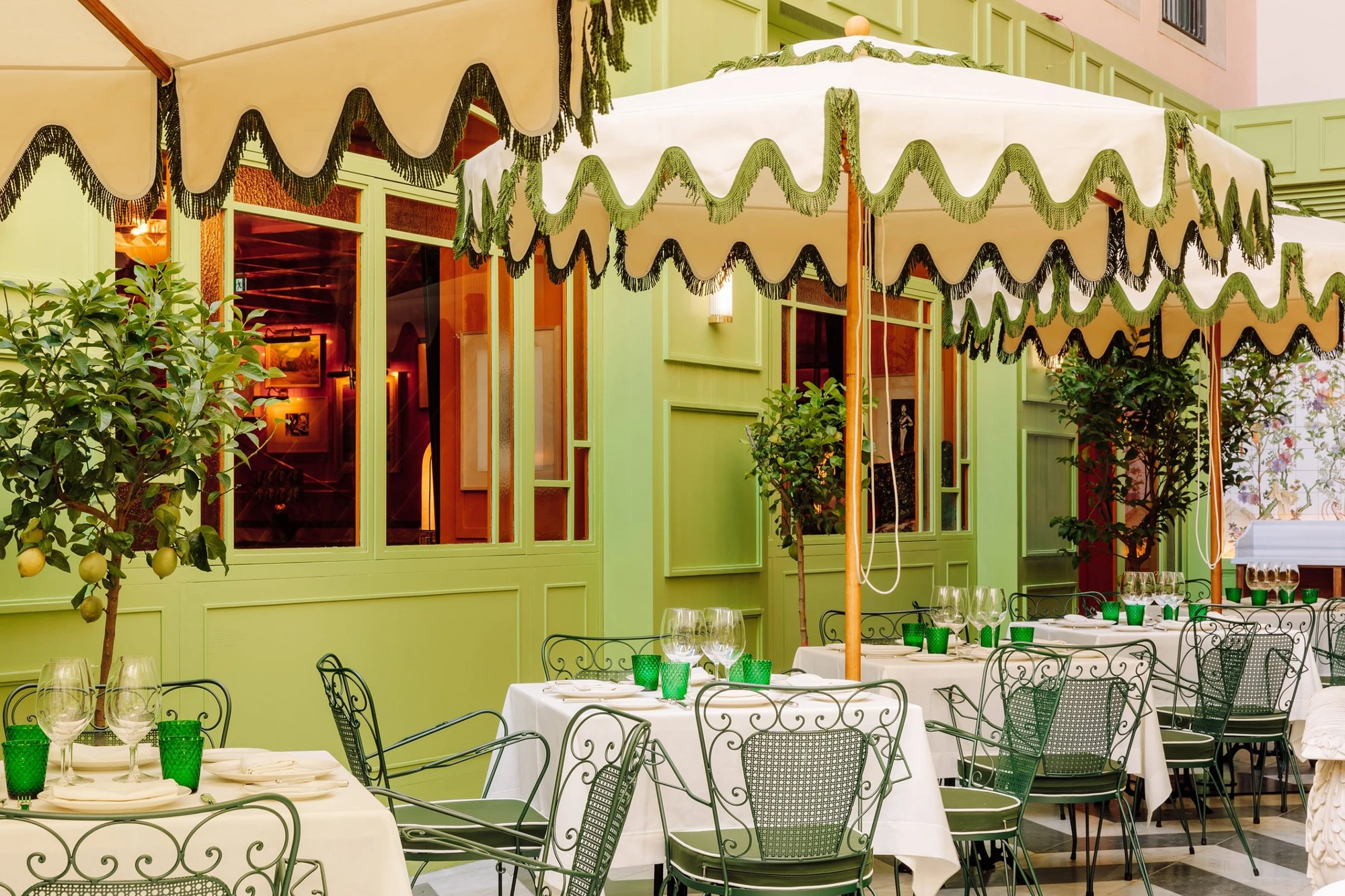 The Ivens by Lázaro Rosa-Violan, photographed by Francisco Nogueira — Rocco's pistachio courtyard terrace with fringed parasols and potted lemon trees.