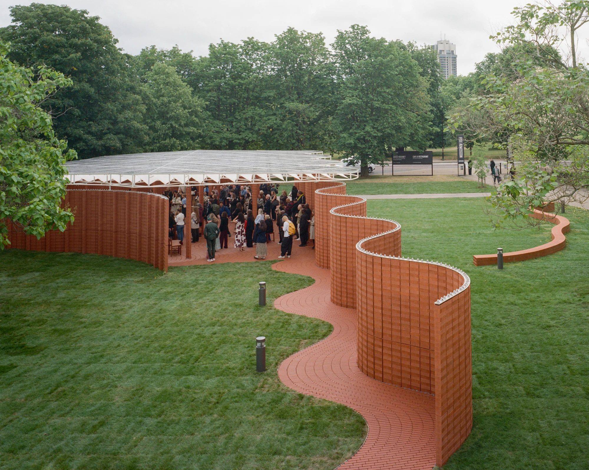 Serpentine Pavilion 2026 by LANZA atelier, photographed by Lorenzo Zandri — aerial view of the pavilion showing the snake-like brick path that uncoils across the lawn to the entrance.