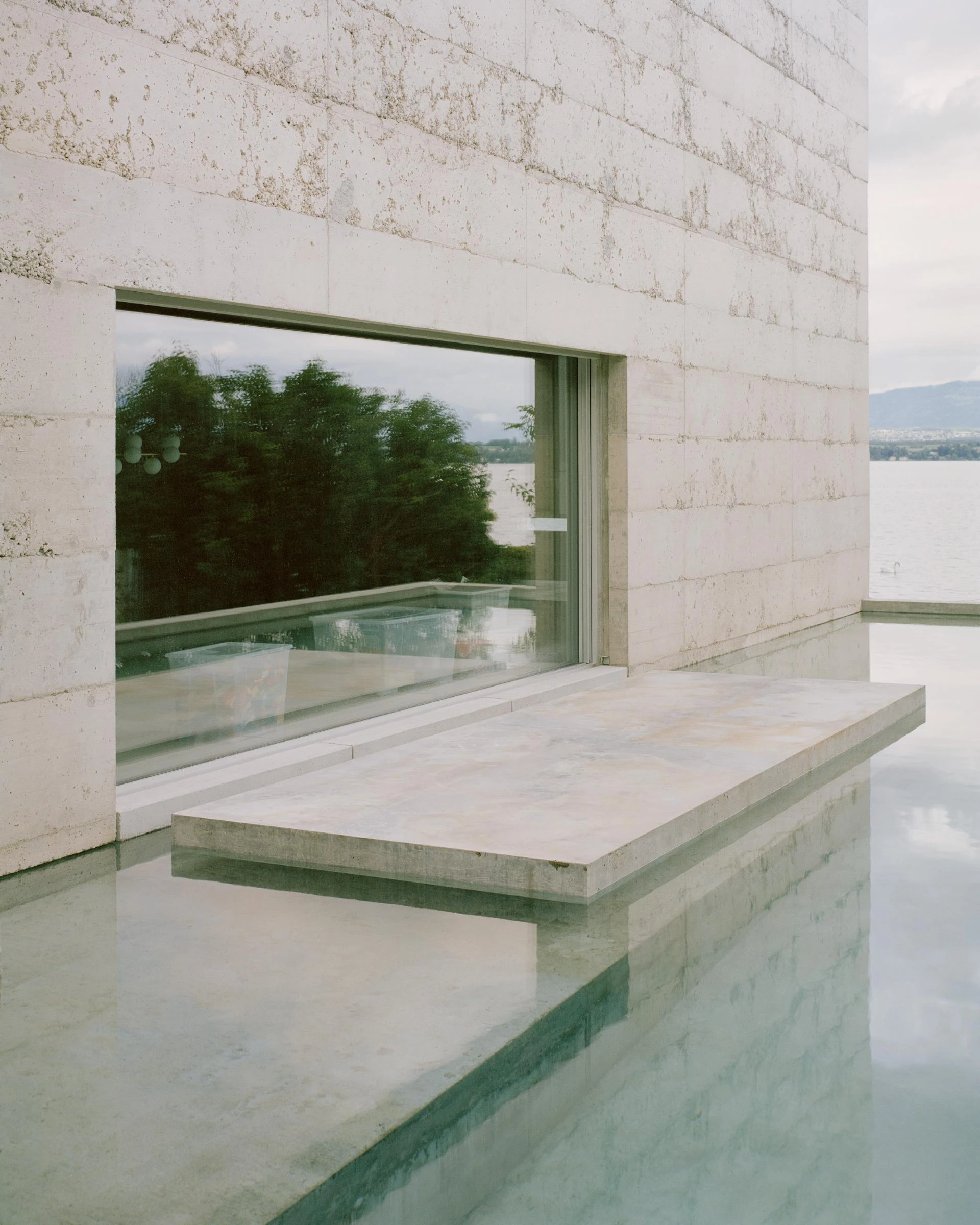 Villa M by Leopold Banchini Architects, Geneva Switzerland, board-formed concrete villa, reflecting water basin, Lake Geneva, Rory Gardiner