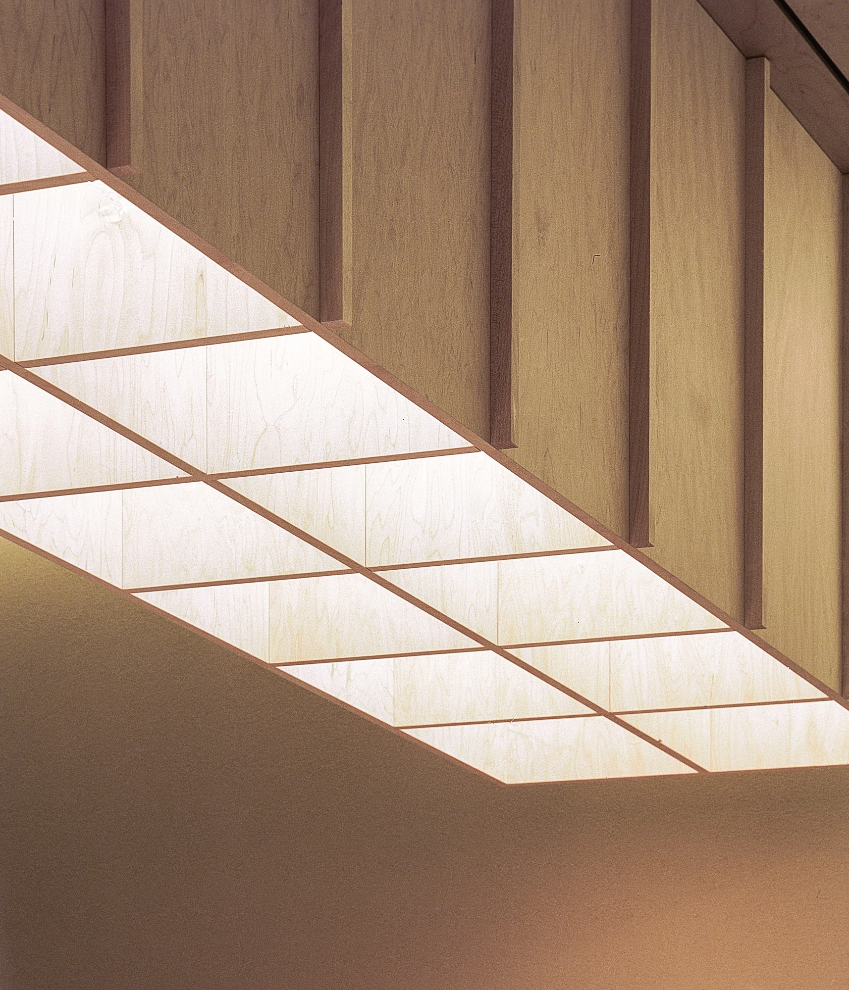 Hos Bobby by NÆRSTUDIO, photographed by Hugo Lütcherath — Detail of the suspended light canopy, translucent panels glowing between slender timber fins.
