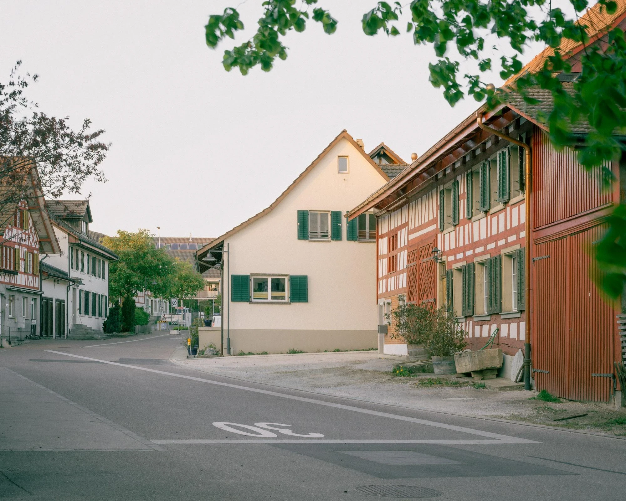 Barn Conversion in Hettlingen by Orso Dettling, photographed by Jeremiah Schwery — Village street in Hettlingen, the half-timbered farmhouse next door framing the project's quiet position inside the protected core