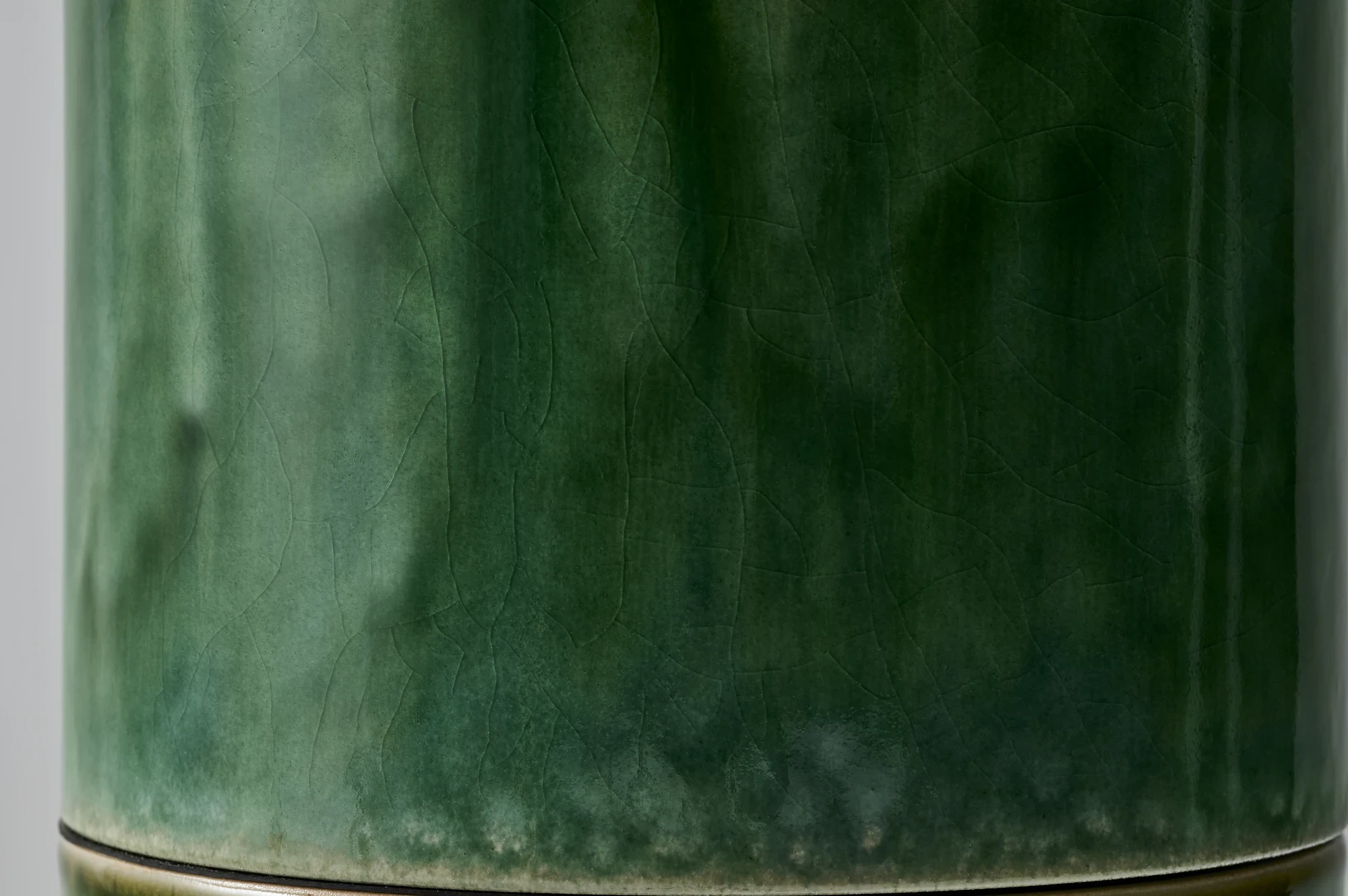 FUSHI by David Caon, photographed by Masayuki Hayashi — Single module in macro, the glaze surface broken by long vertical drip-lines and a faint web of crackle in the deep green