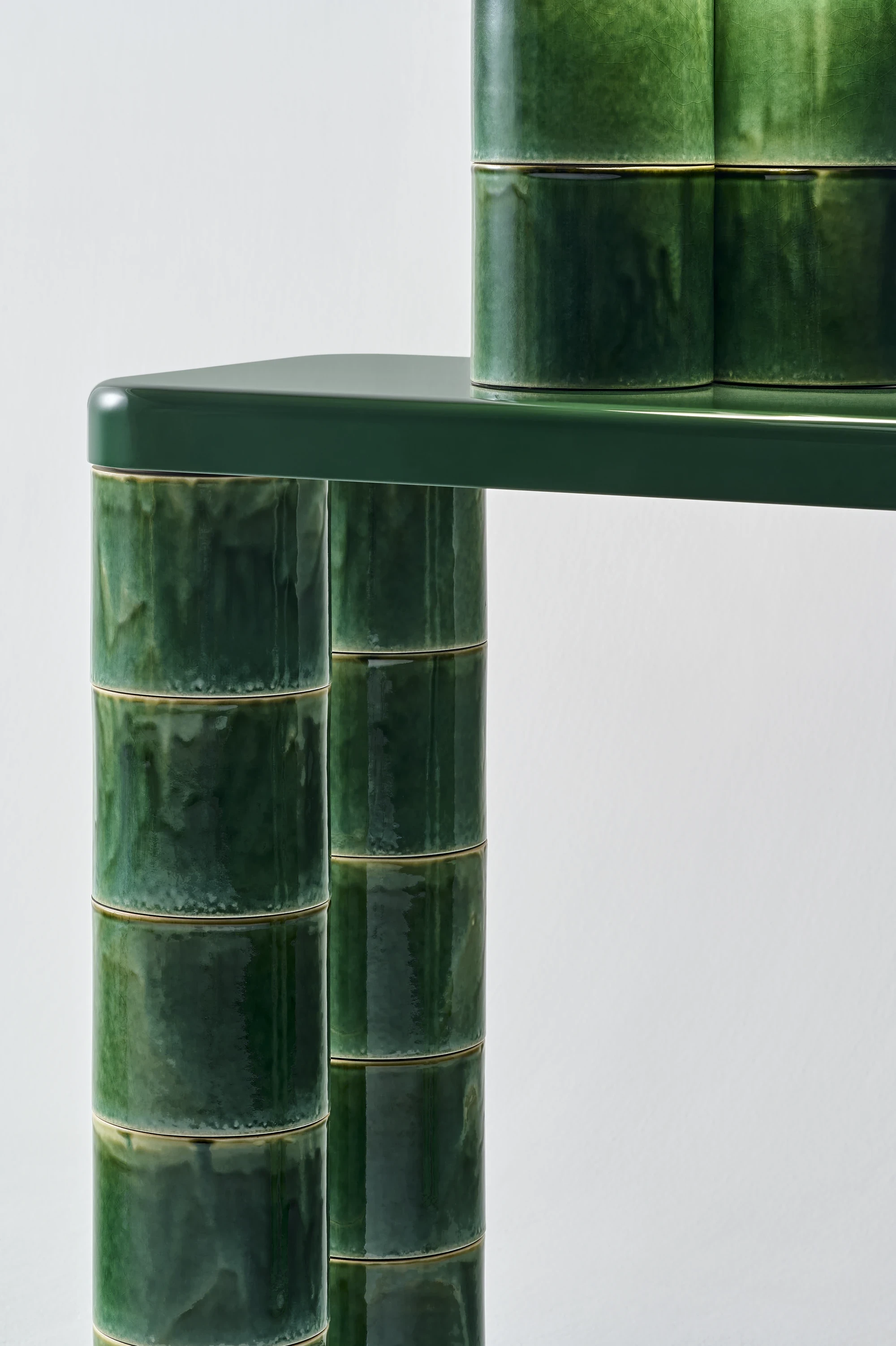 FUSHI by David Caon, photographed by Masayuki Hayashi — Detail of two leg-pairs of the console meeting the dark-green top, every cylindrical module showing a distinct pattern of glaze drips and crazing