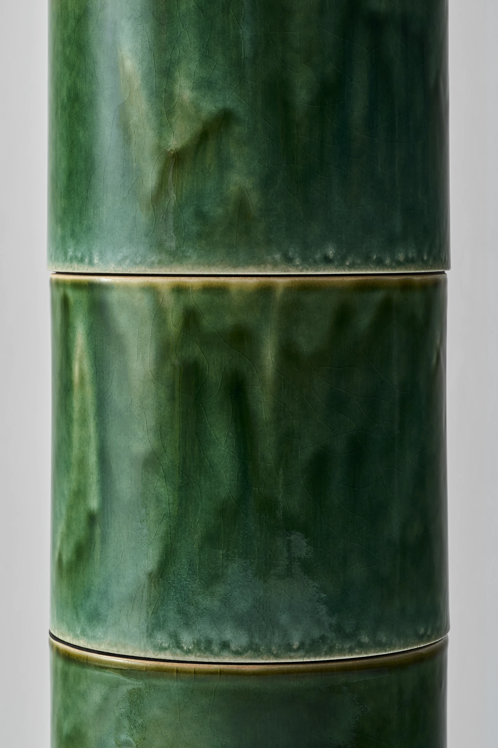 FUSHI by David Caon, photographed by Masayuki Hayashi — Macro of two stacked modules and their shared joint, where Fudogama's Oribe glaze has pooled at the rim into a band of caramel and the body shows a fine network of crackle