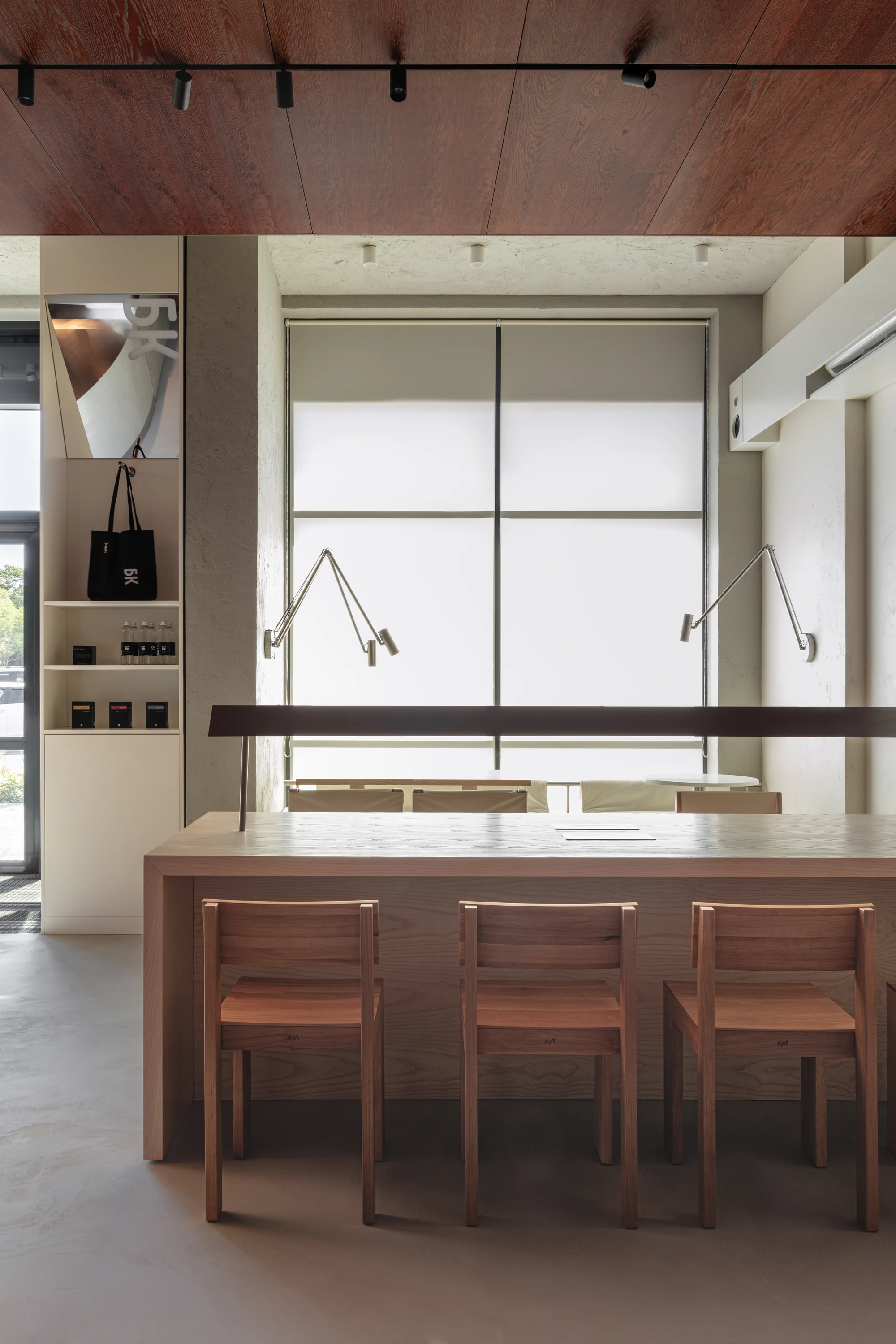 Biblioteka Coffee by Kidz, photographed by Alexander Plyaskin — the silence room photographed against the panoramic window, a long ash table flanked by oak chairs and two articulated brass lamps reflected against the translucent shade.