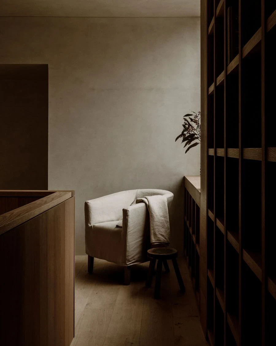 Barrancas by PPAA, photographed by Luis Garvan — a tan leather sling chair beside a timber credenza with glazing open behind it, the object and the garden trading position in the composition.