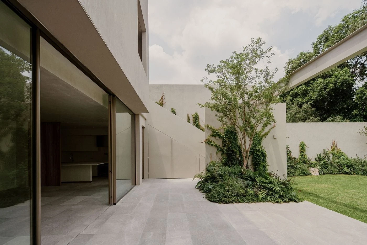 Barrancas by PPAA, photographed by Luis Garvan — a steel walkway bridges the garden level with stone stairs below and the rear plaster cube above, a cross-section through the vertical organisation.