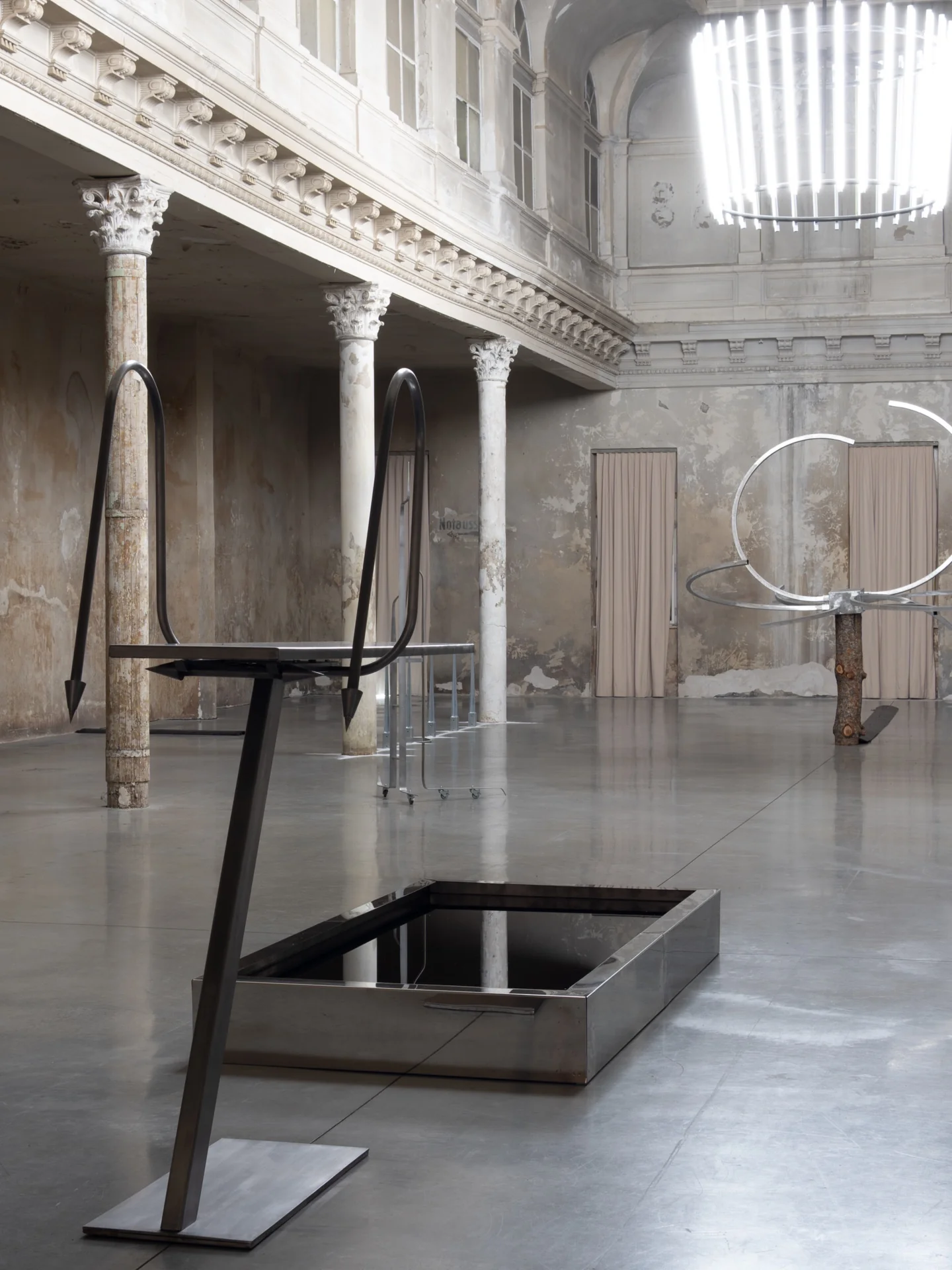 Everything Comes Together While Pushing All Apart by Roxana Morar — Andrei Arion's harpoon-tipped frame straddling a polished steel trough by Claudiu Lazar, Ana Ionescu's circular metal ring threading through the centre.